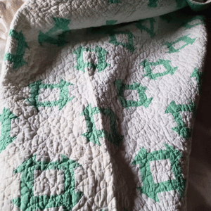 White and green patterned quilt.