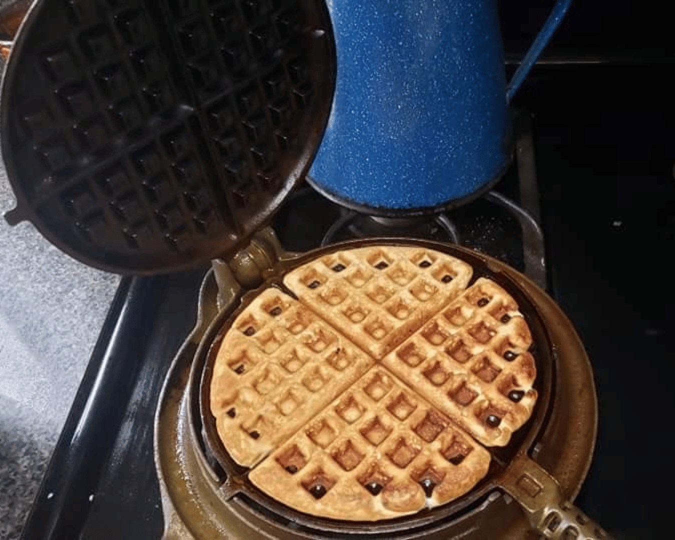 A waffle is being cooked in a waffle iron on a stove