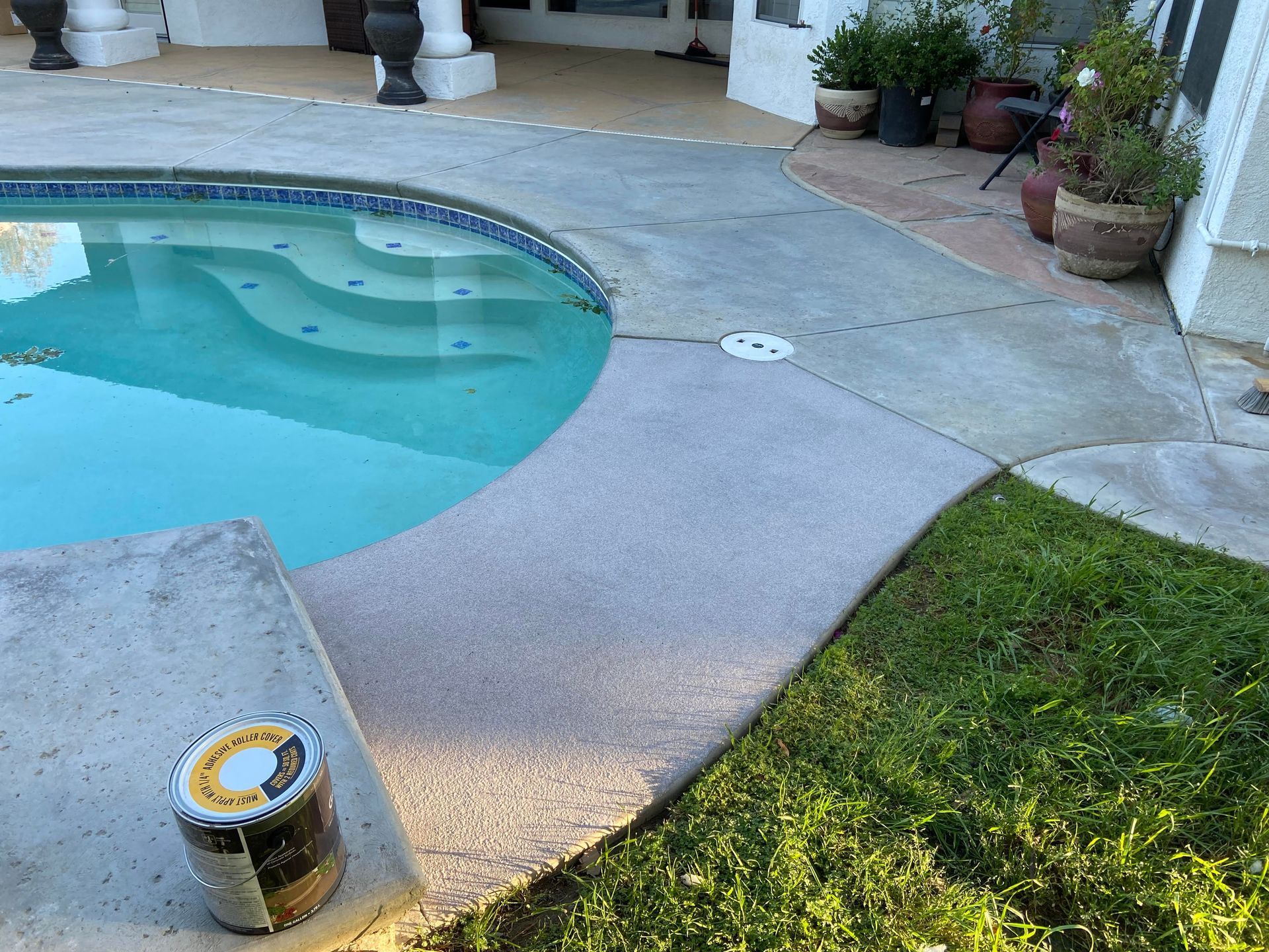 A concrete walkway next to a swimming pool