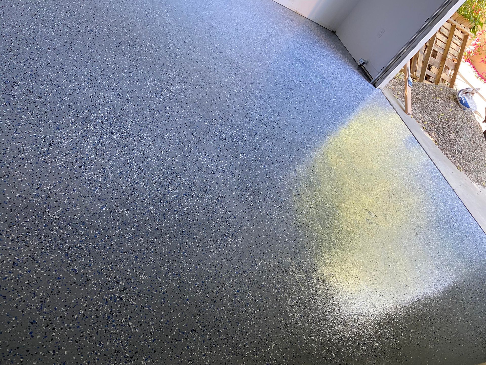 A close up of a concrete floor with a door in the background.
