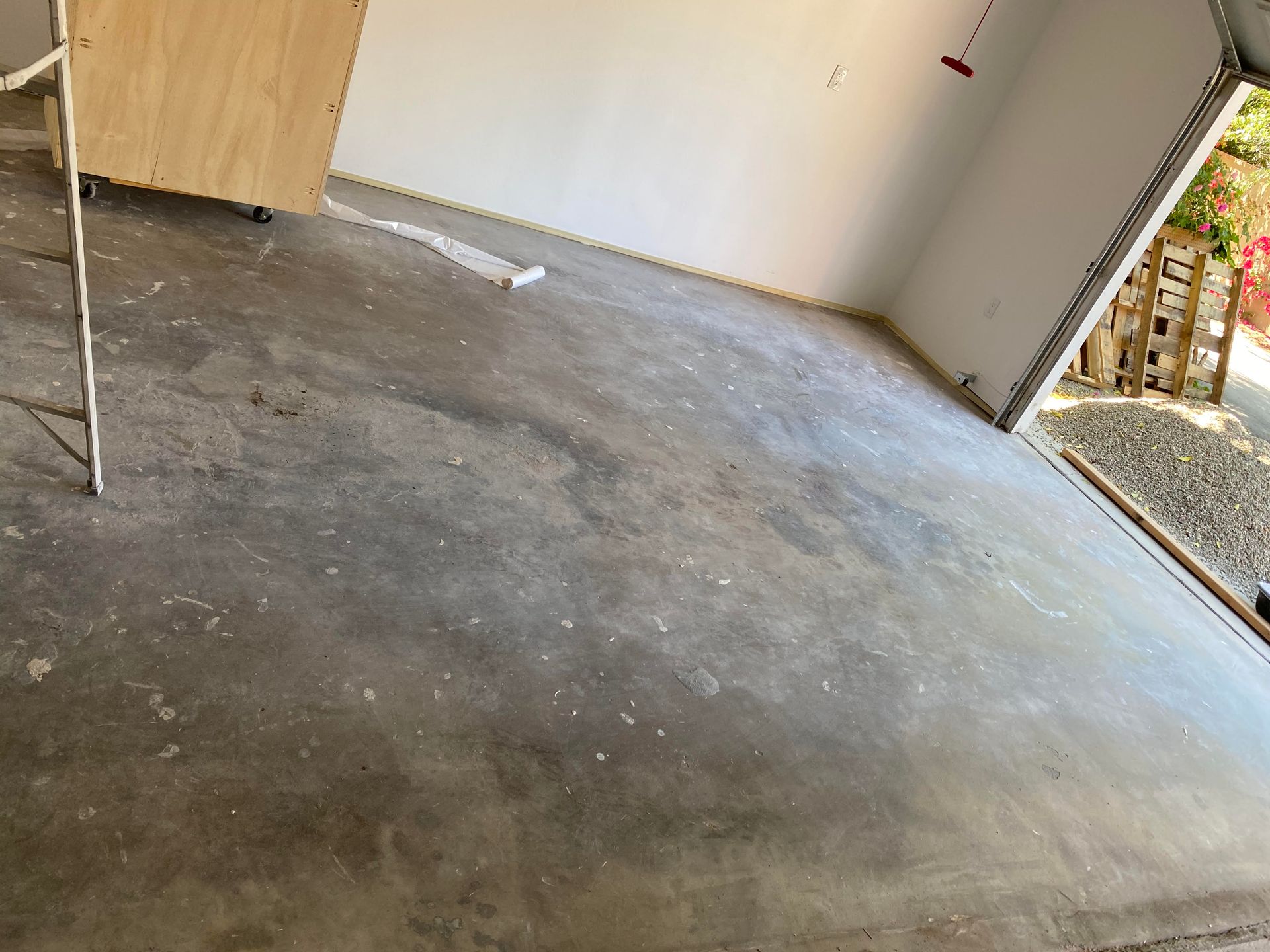 A concrete floor in a garage with a wooden box on it.