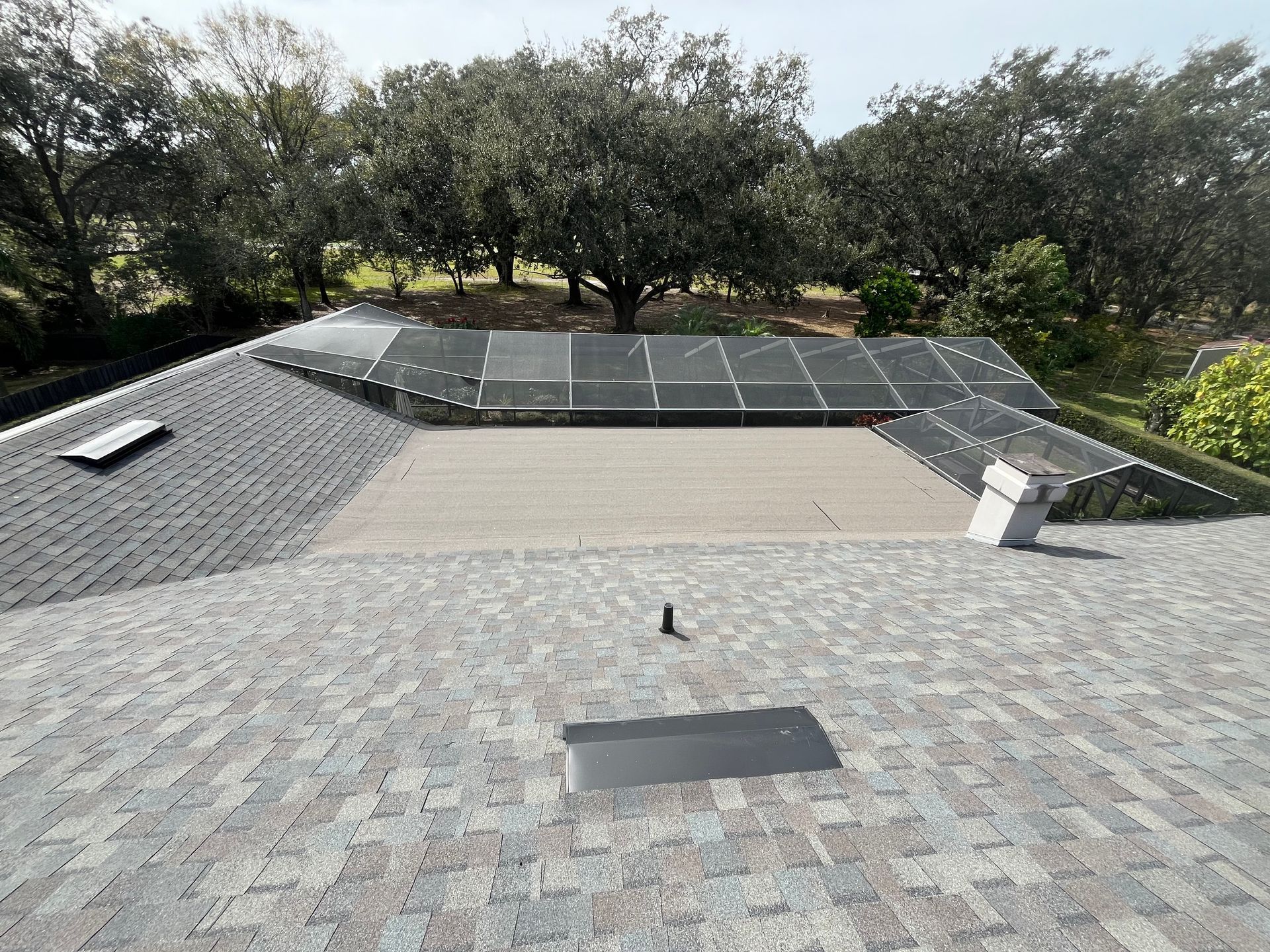 An aerial view of a residential neighborhood with a driveway leading to a house.