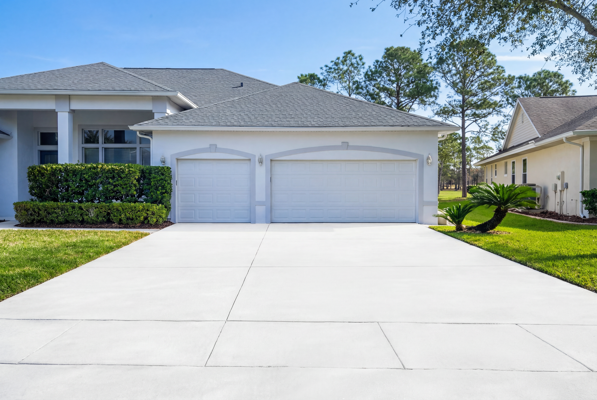 A driveway leading to a large white house