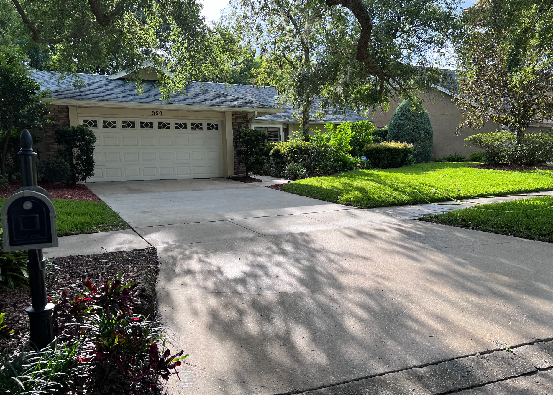 A driveway leading to a house with a garage and a mailbox.