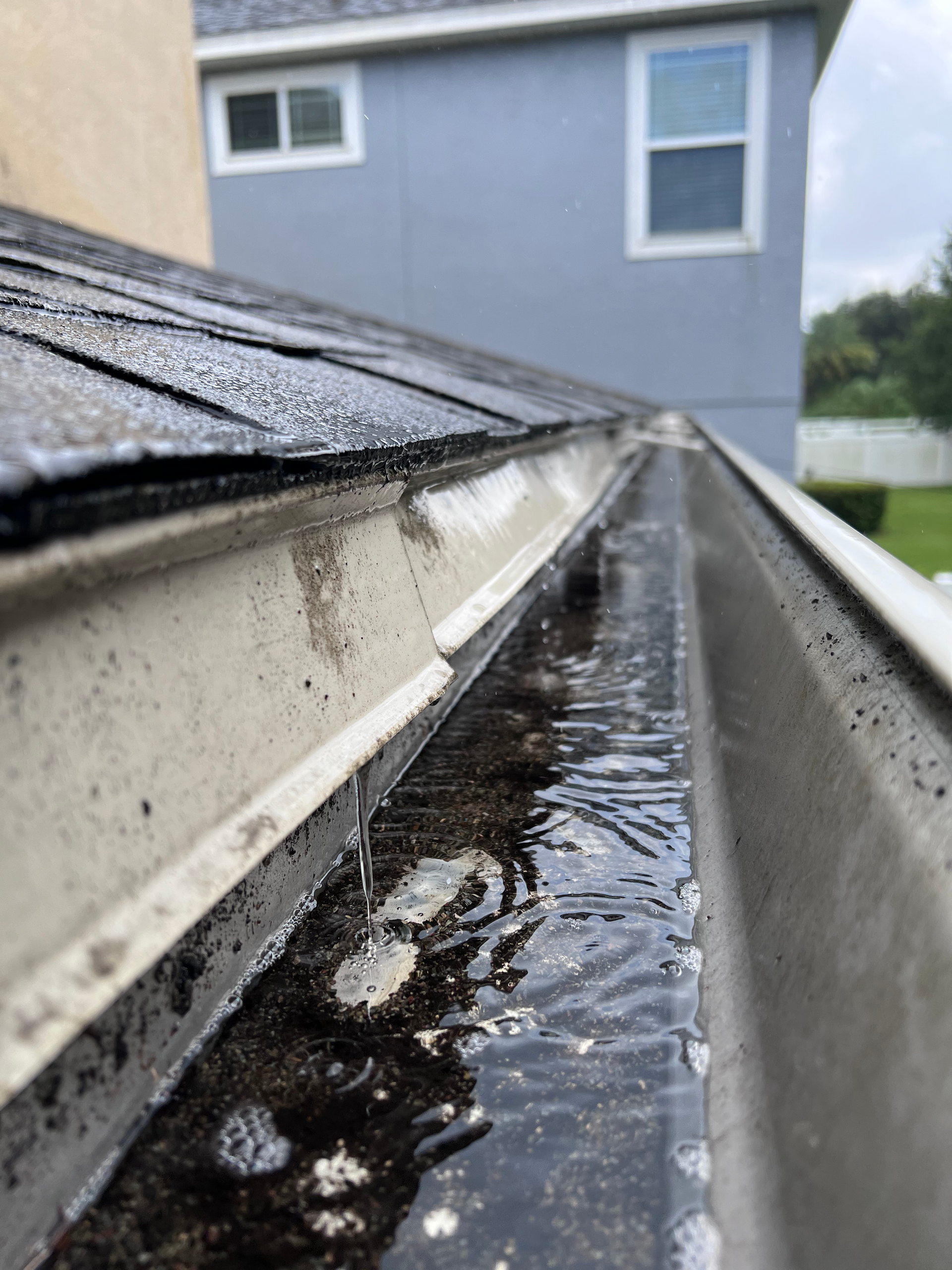 A close up of a gutter with water coming out of it.