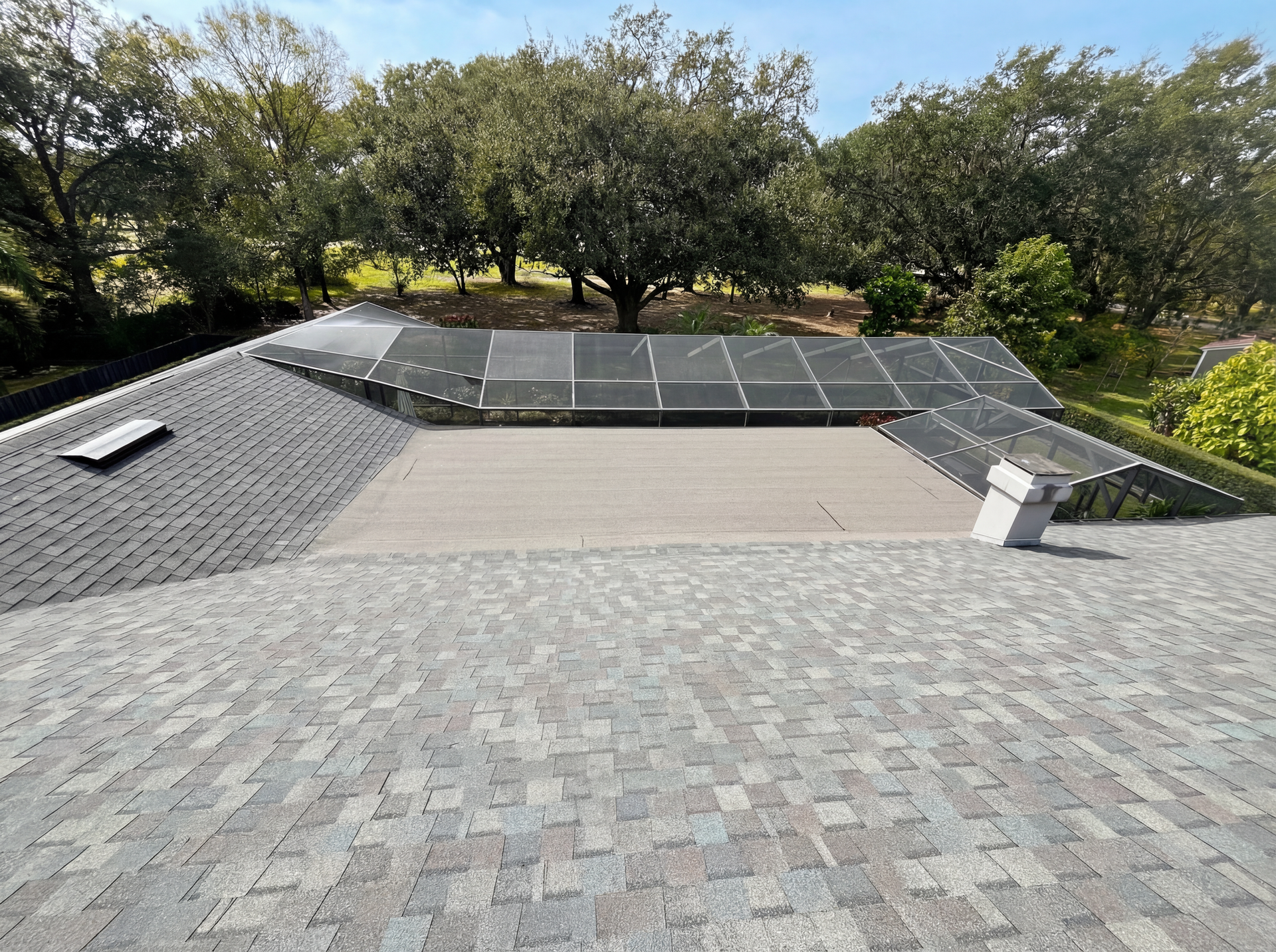 An aerial view of a residential neighborhood with a driveway leading to a house.
