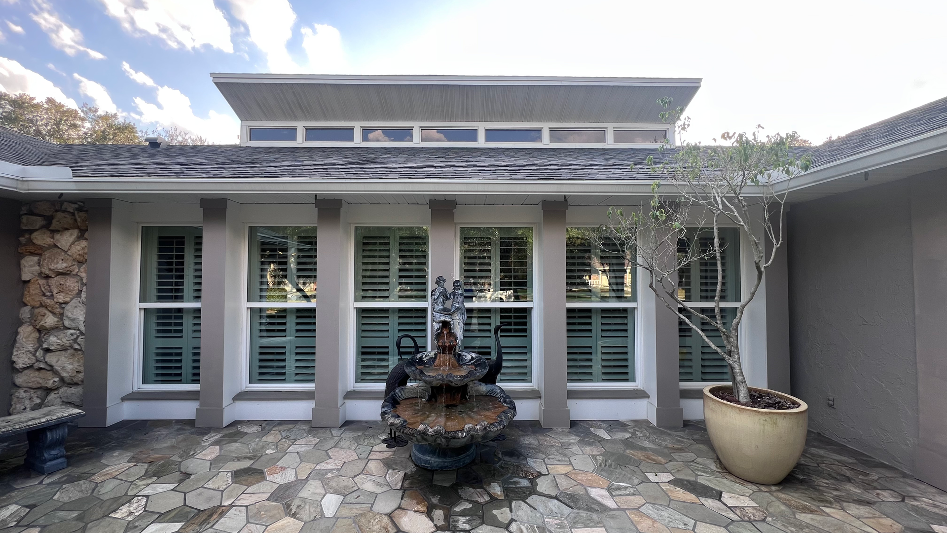 A house with a fountain in front of it