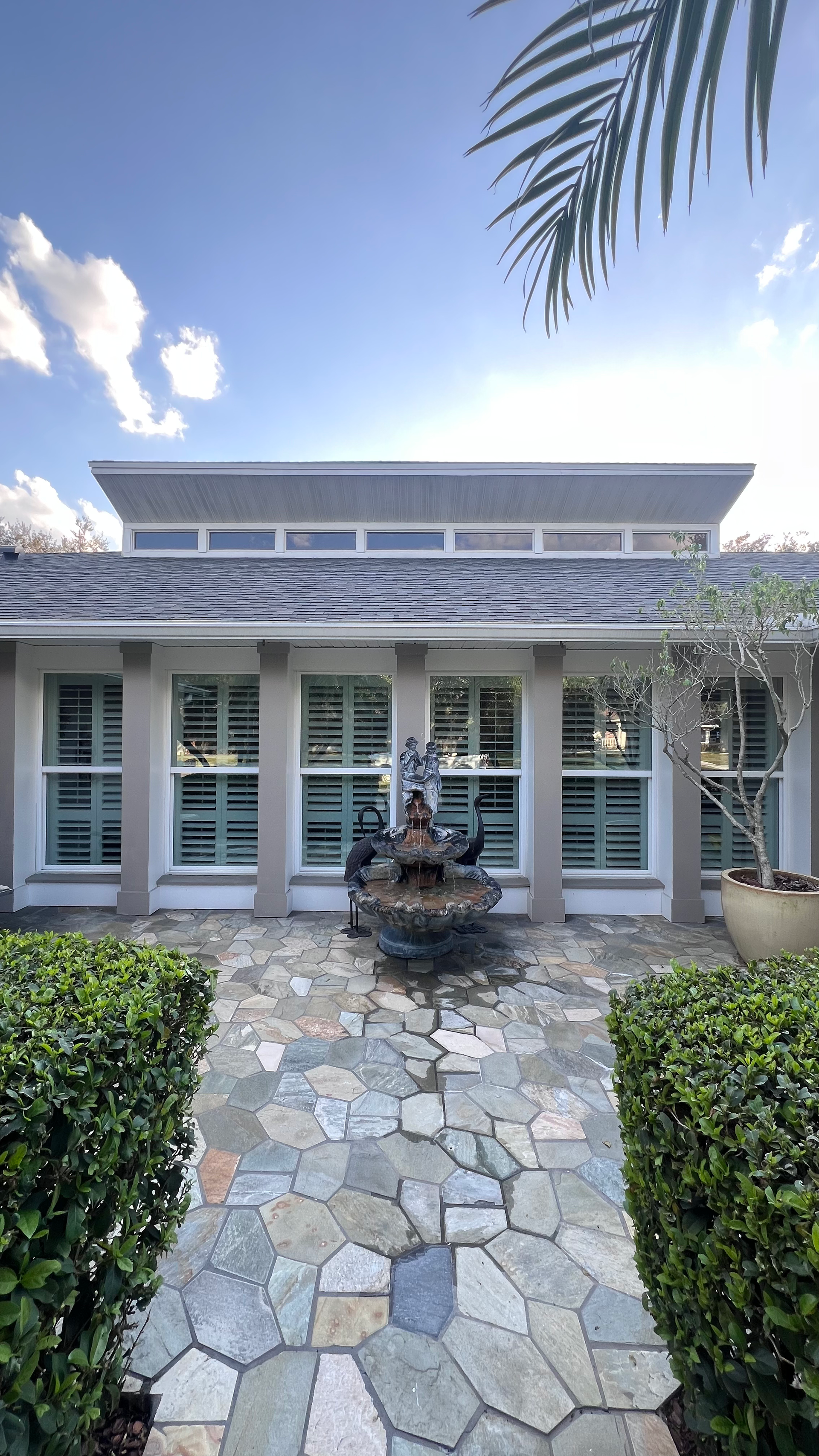 A large house with a fountain in front of it.