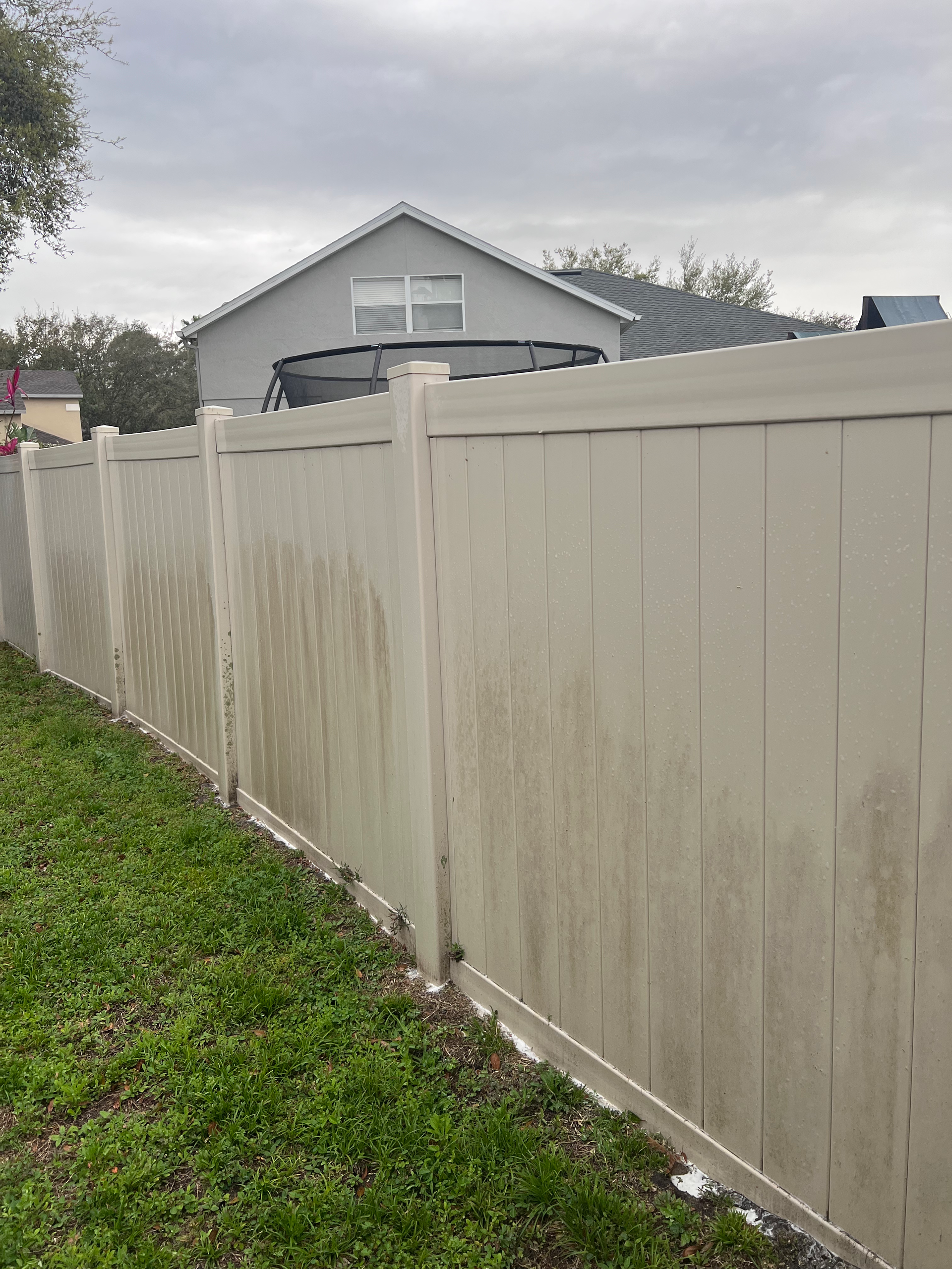 A dirty white gate is sitting on top of a lush green field.