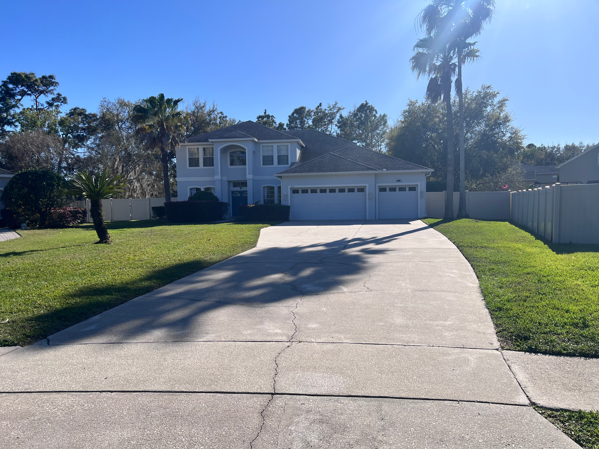 A driveway leading to a large white house