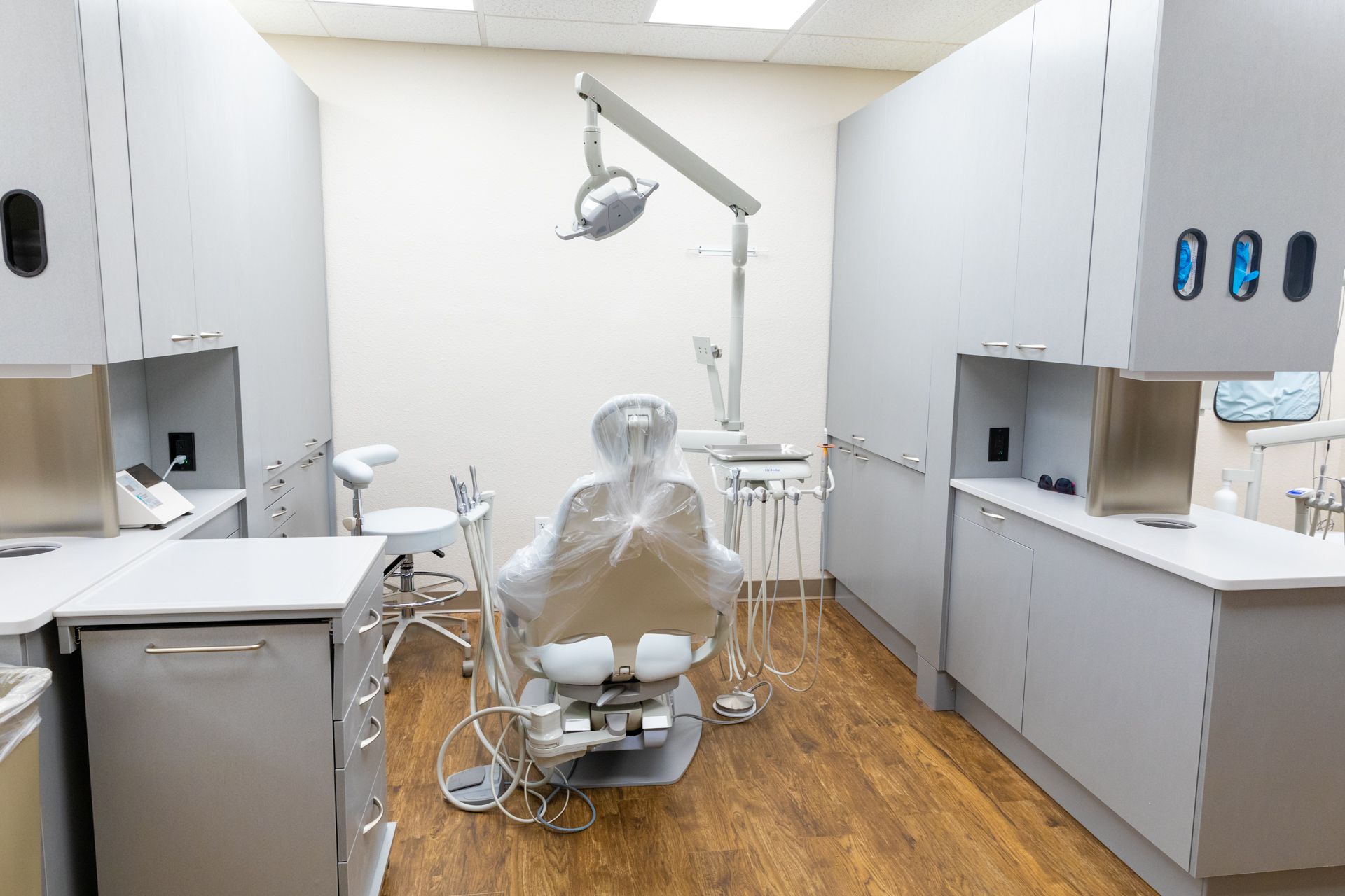 A dental office with a dental chair and cabinets.