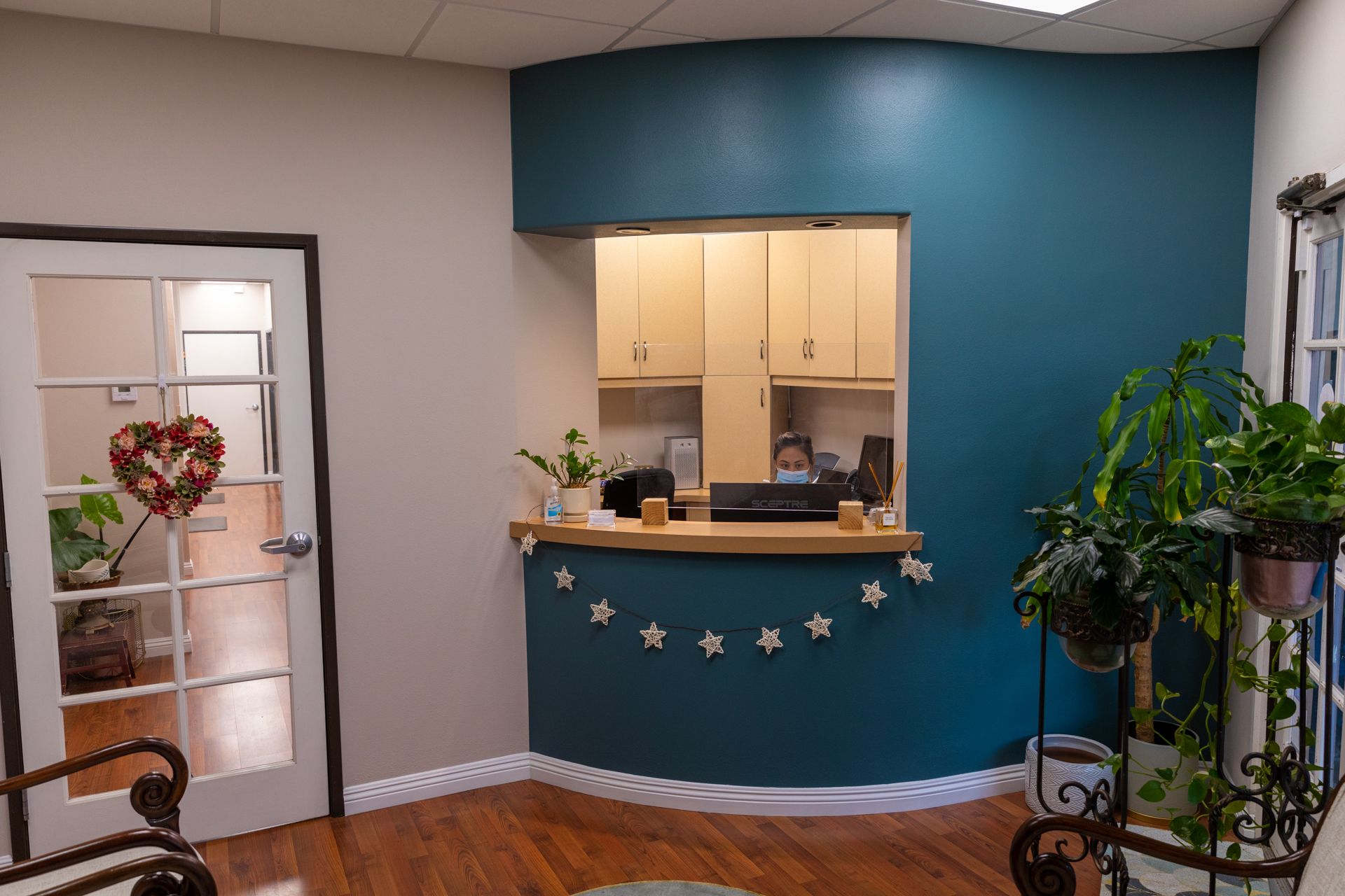 A waiting room with a blue wall and a wooden floor.