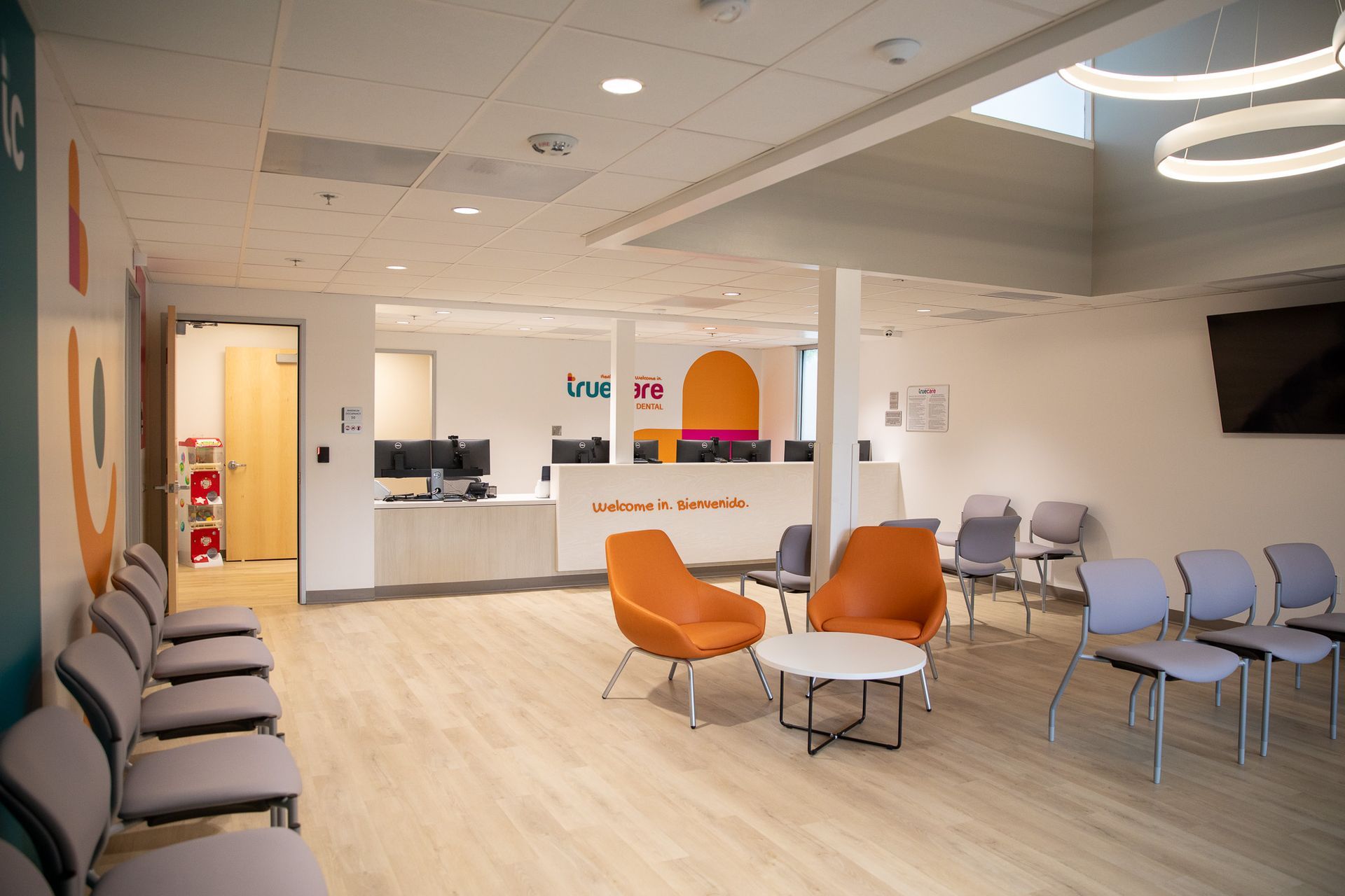 A waiting room with chairs , tables , and a counter.