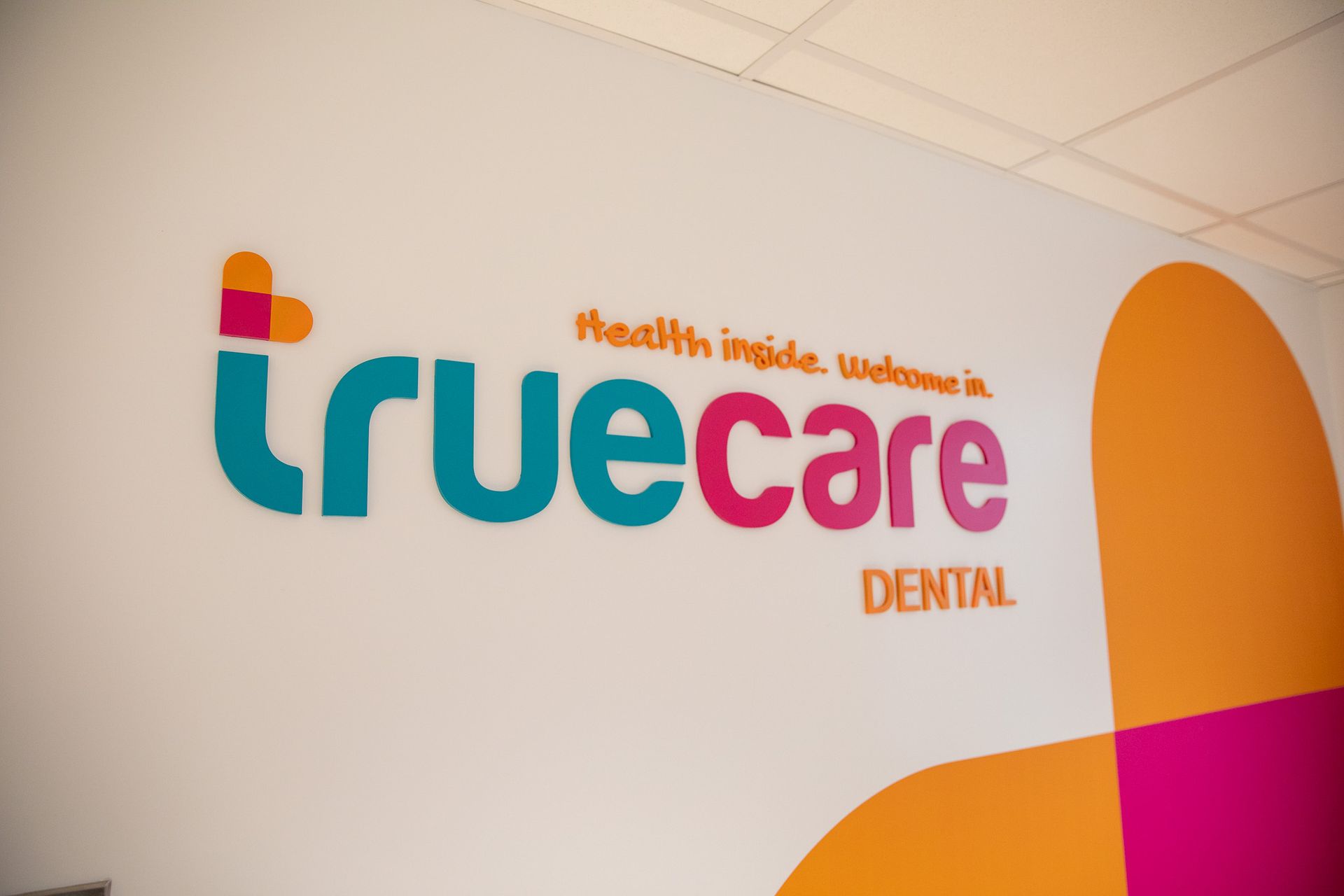 A wall with a truecare dental logo on it