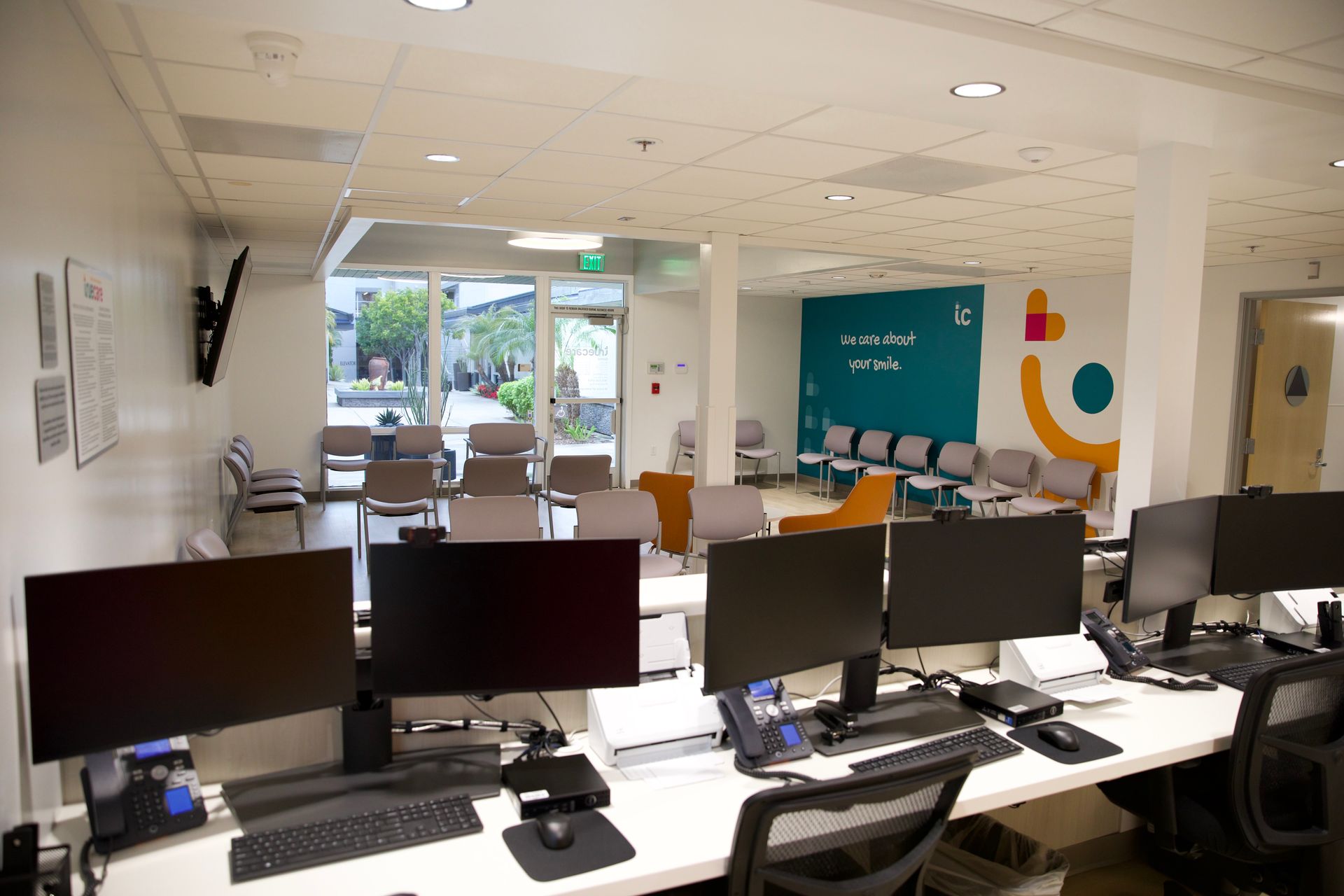 A row of computer monitors are sitting on a desk in an office.