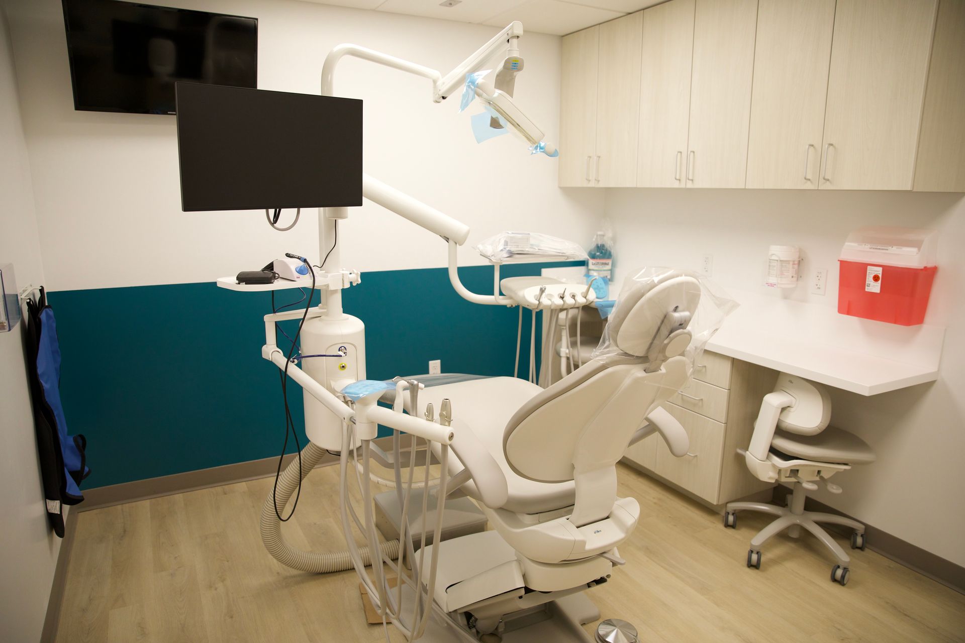 A dental office with a dental chair and a television.