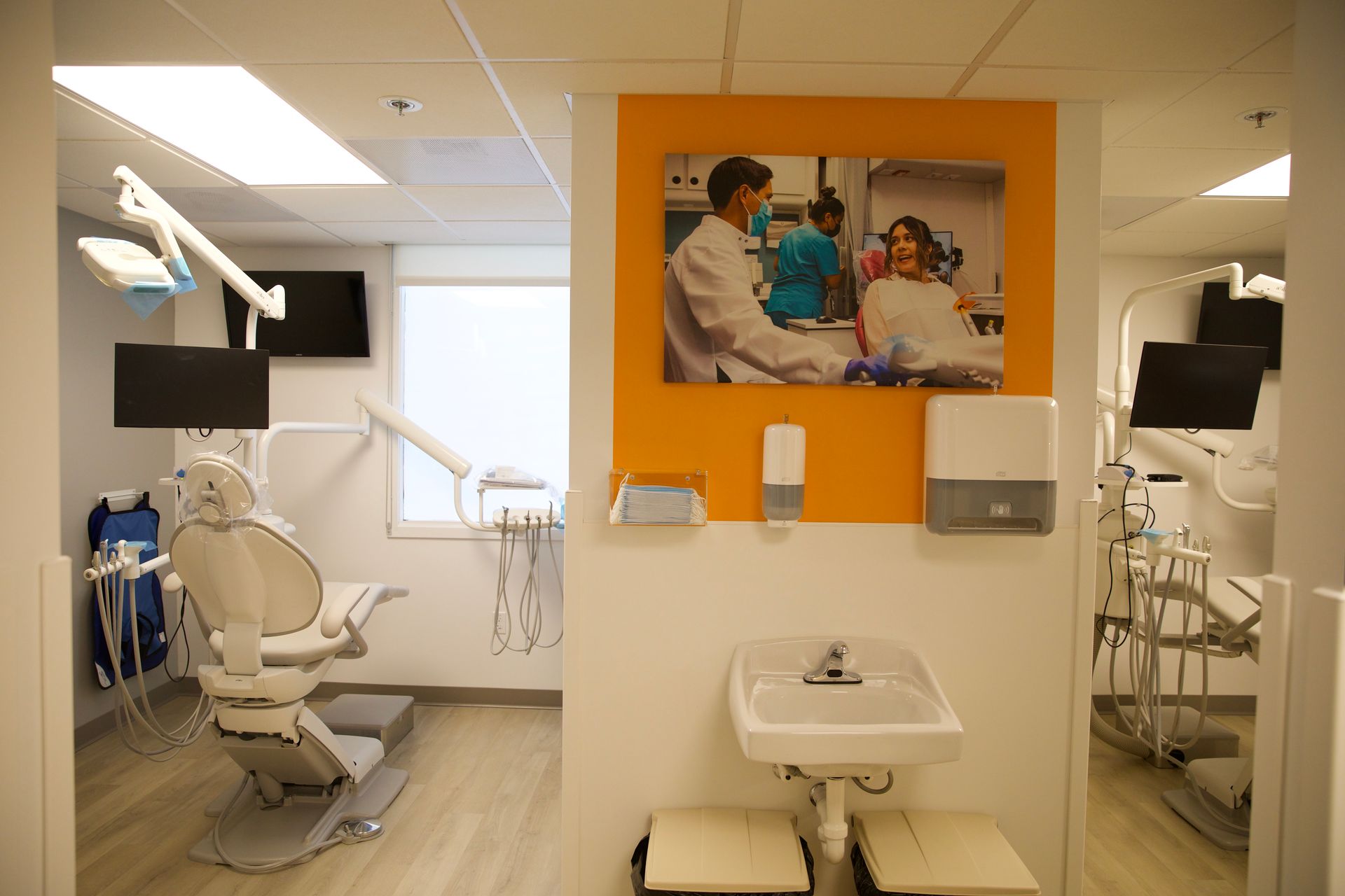 A dental office with a sink and a painting on the wall.