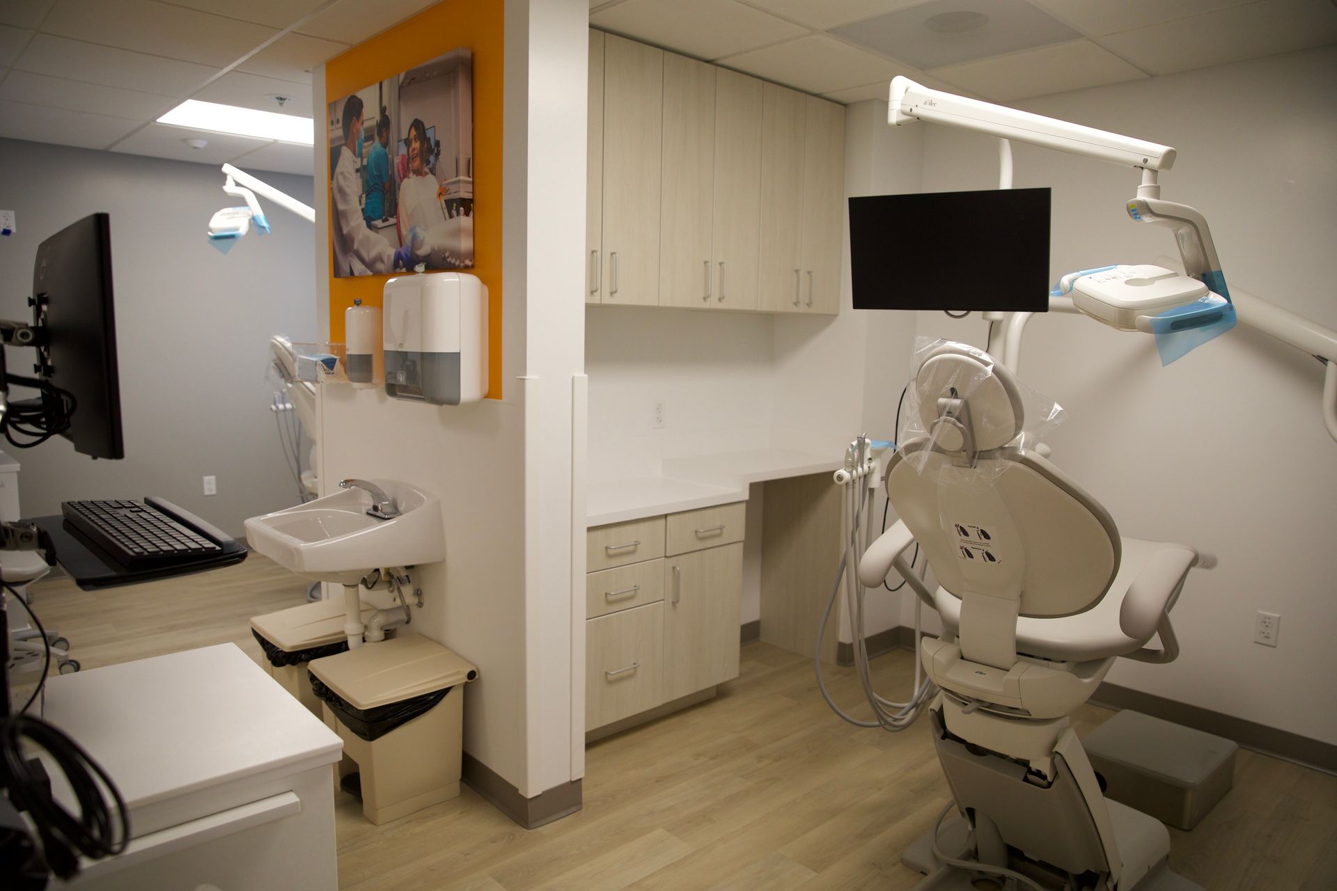 A dental office with a dental chair and a sink.