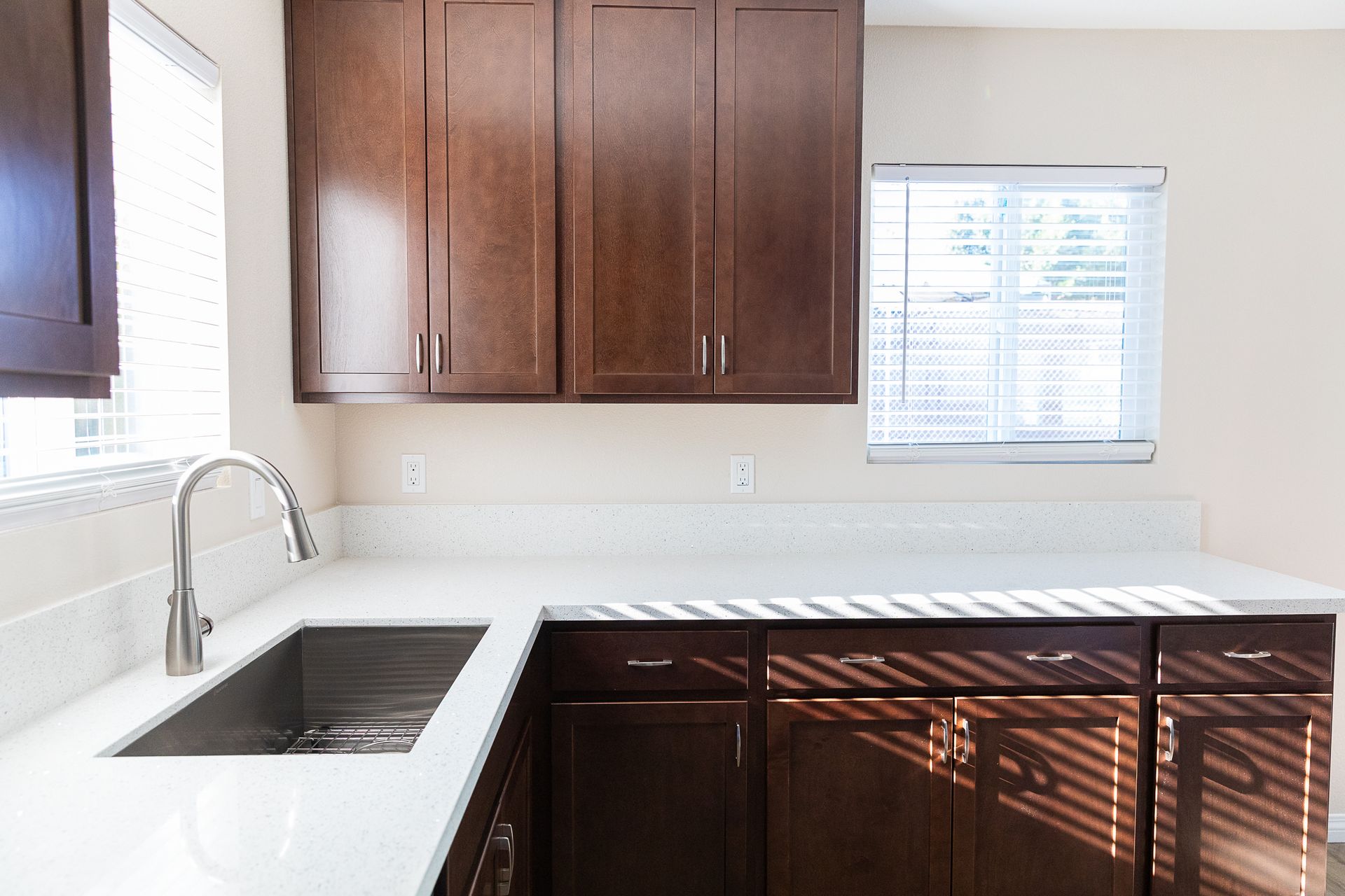 A kitchen with a sink , cabinets , and a window.