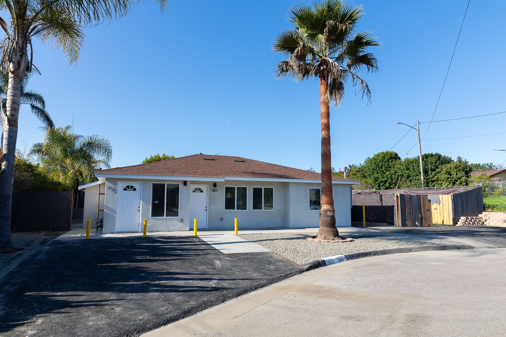 A white house with a palm tree in front of it