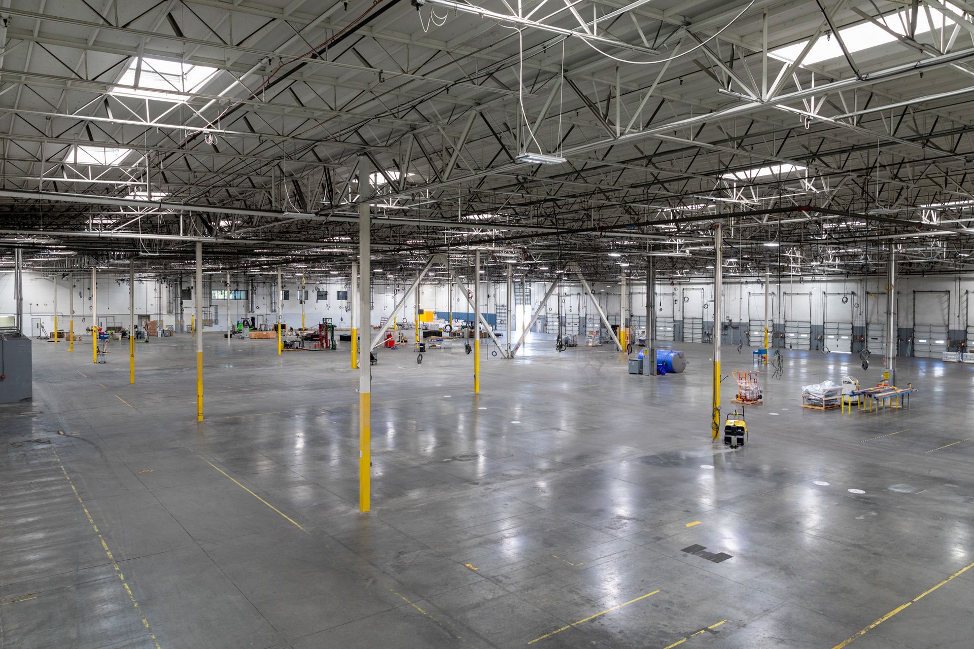 A large empty warehouse with a lot of lights on the ceiling.