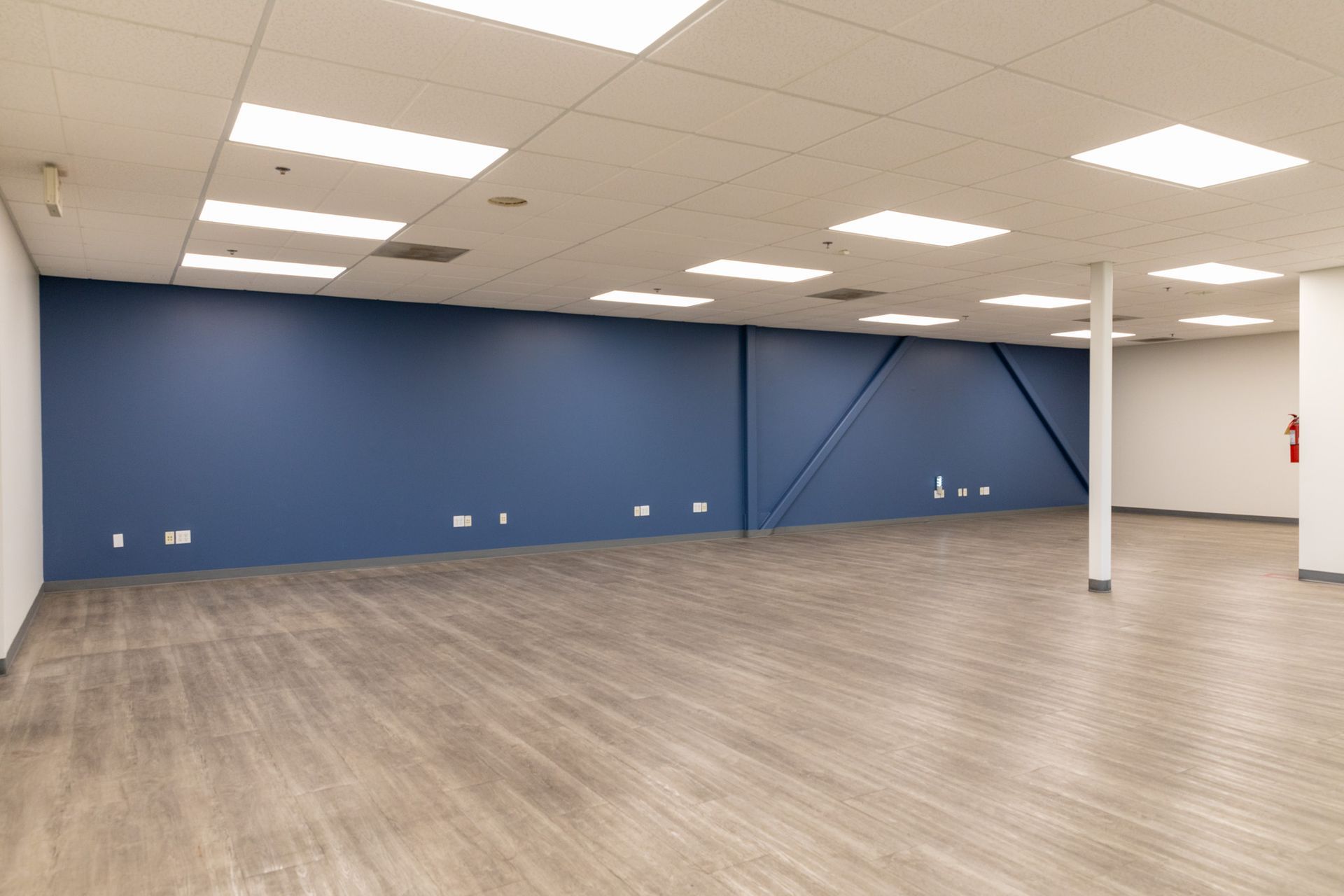 A large empty room with wooden floors and blue walls.