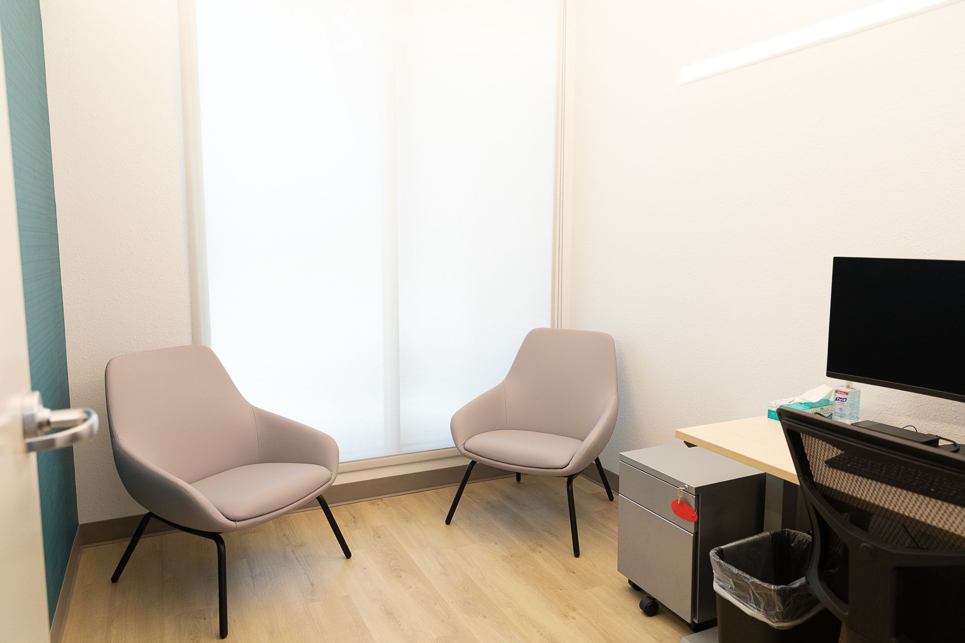 There are two chairs and a desk in the room.