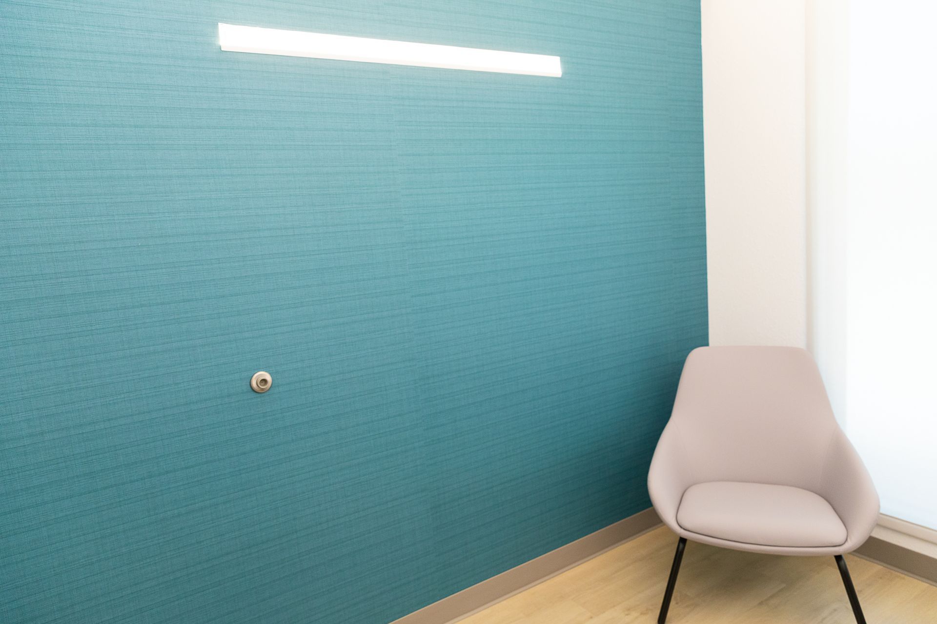 A chair is sitting in a room with a blue wall.