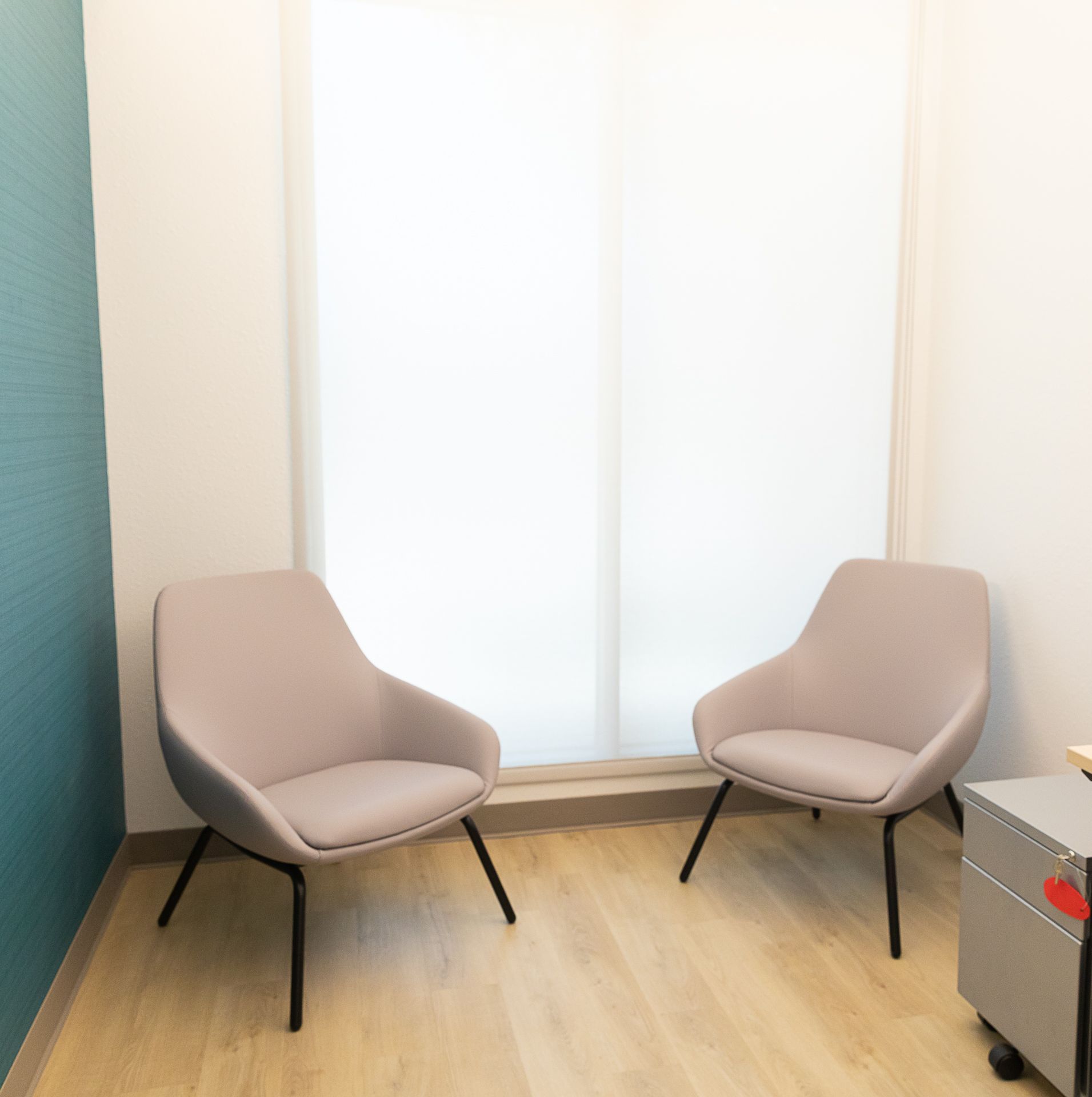 Two chairs are in a room next to a window