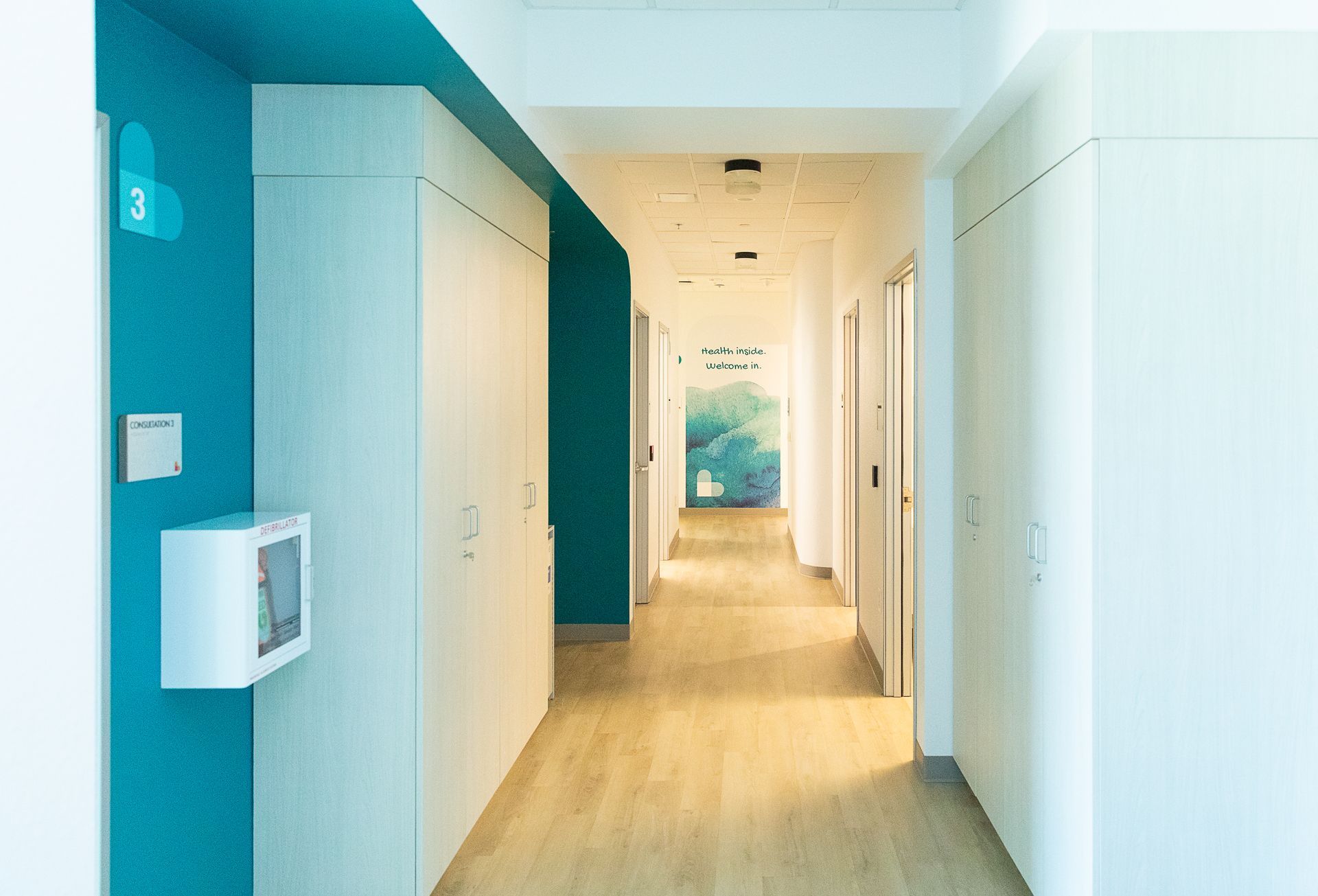 A long hallway with blue and white walls and wooden floors.