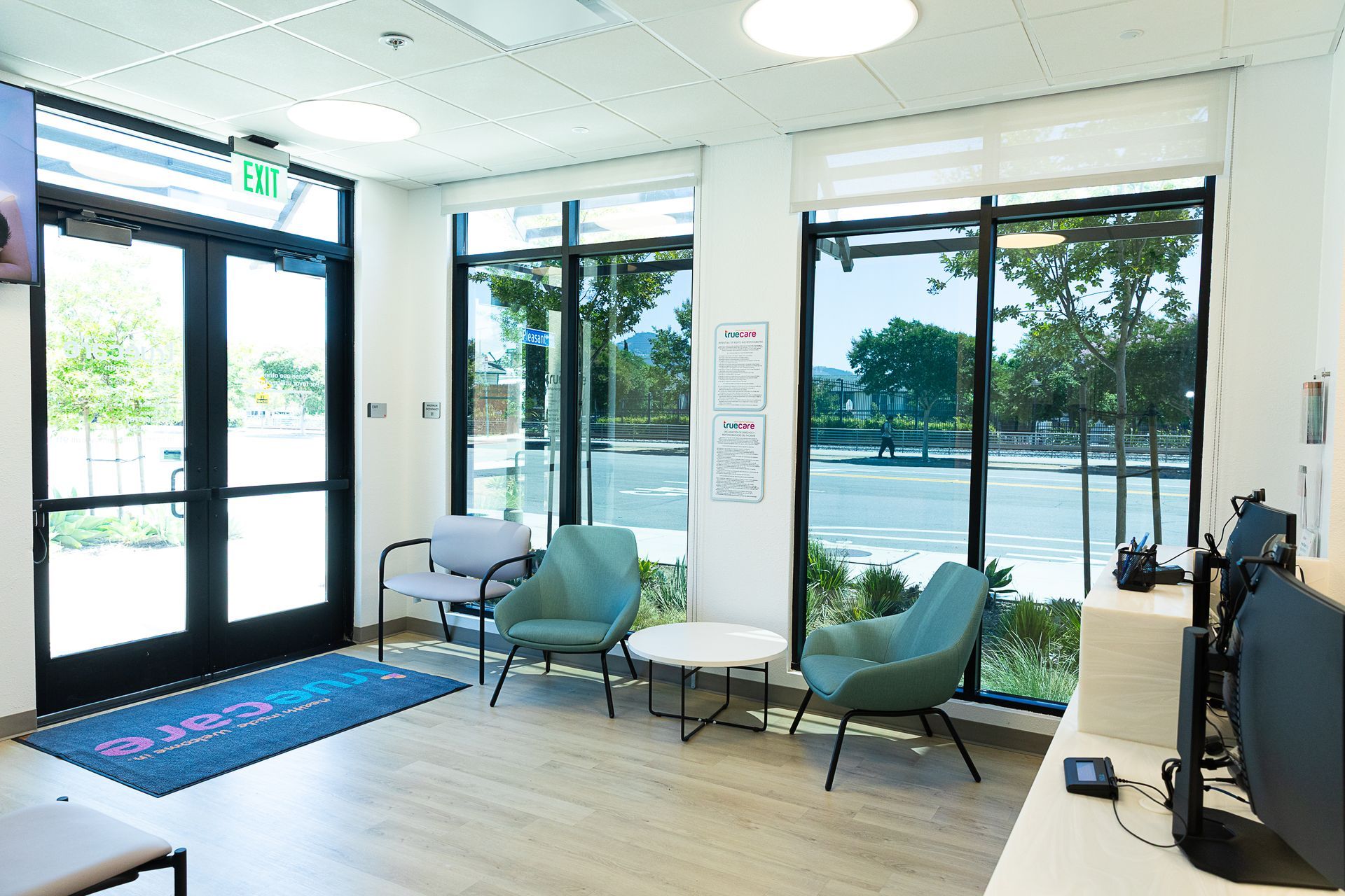A waiting room with a lot of windows and chairs