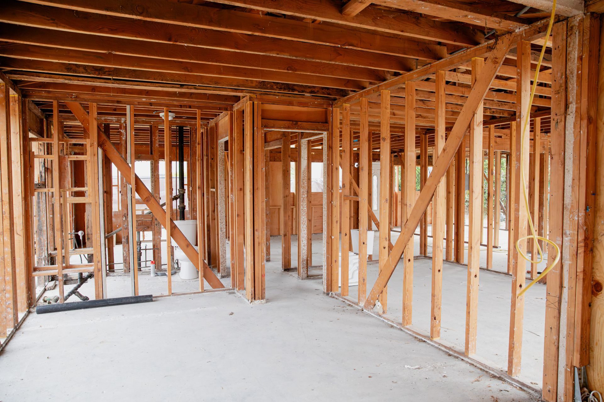 A house is being built with wooden beams and a concrete floor.