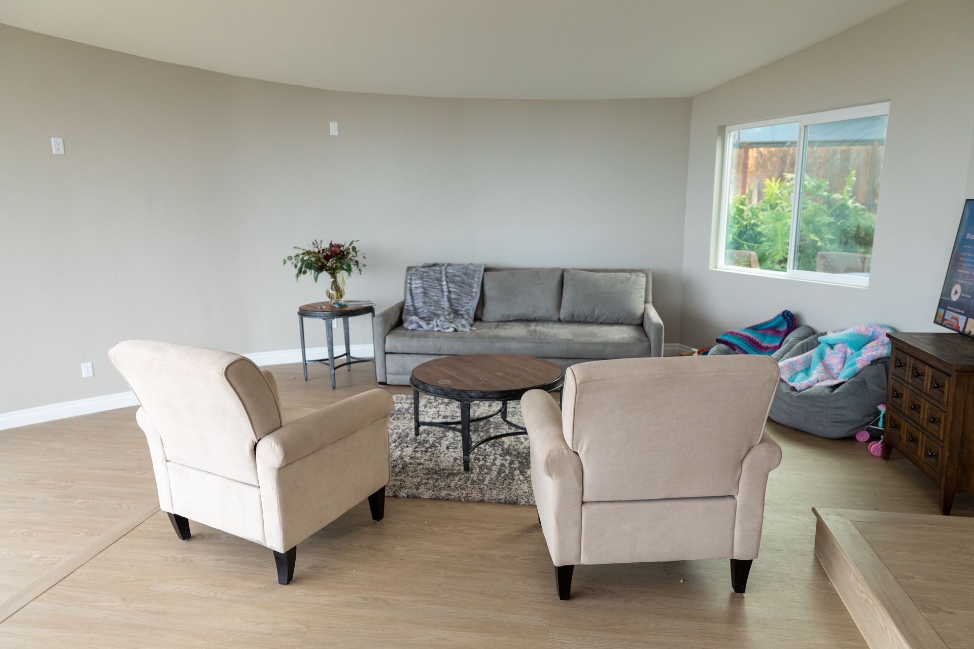 A living room with a couch , chairs , and a table.