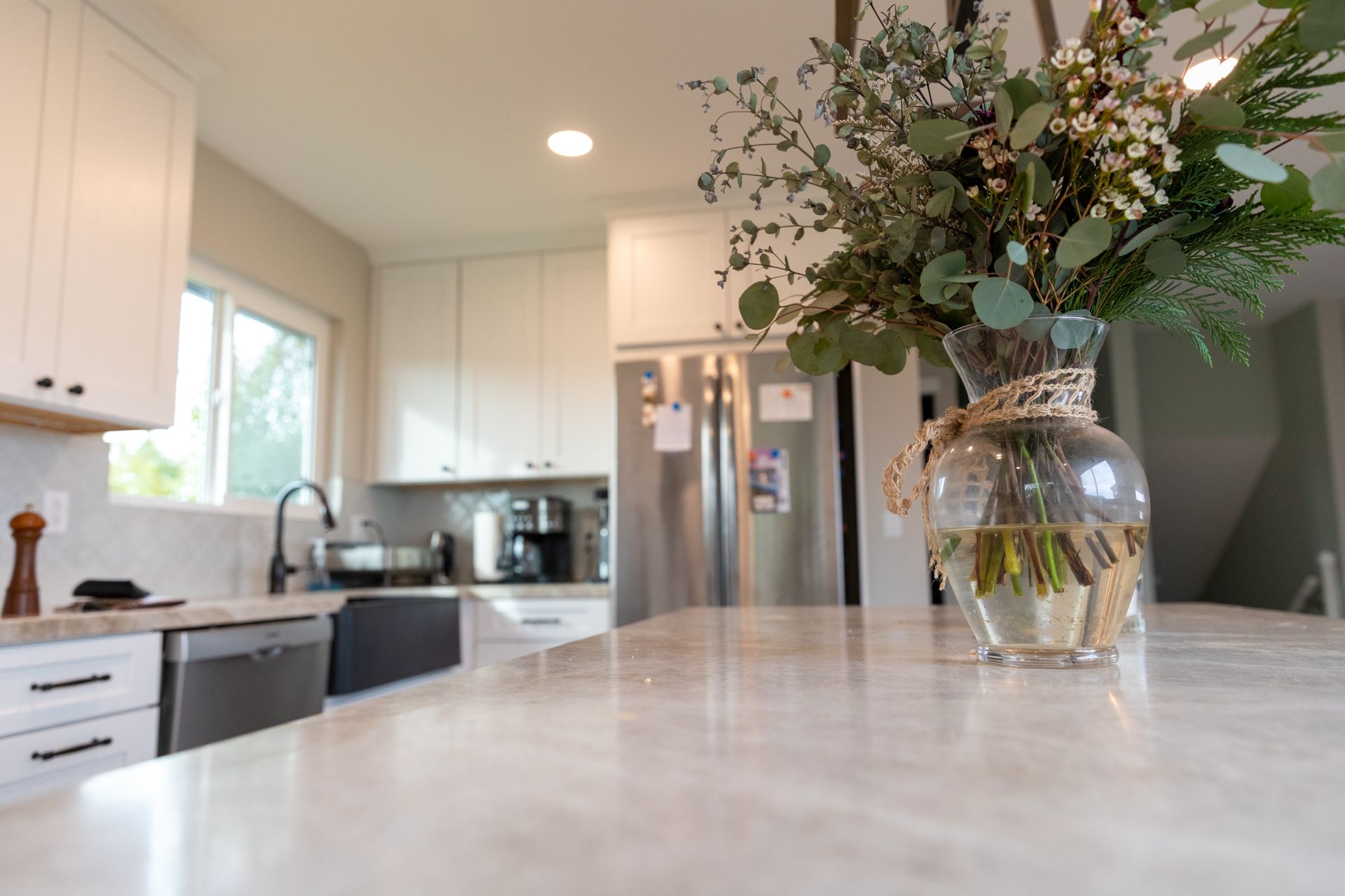 A kitchen counter with a vase of flowers on it.