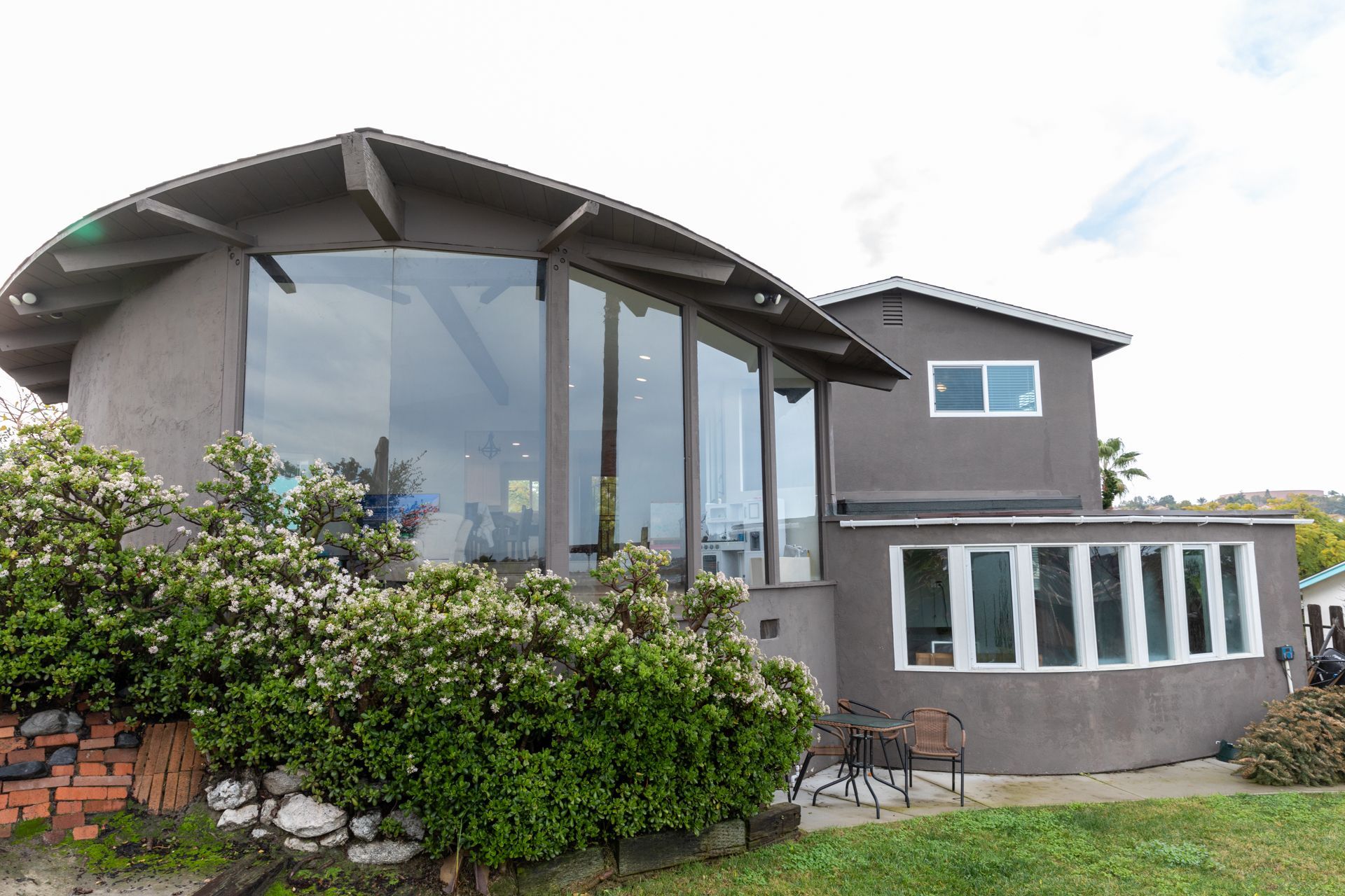 A large house with a lot of windows and a curved roof.