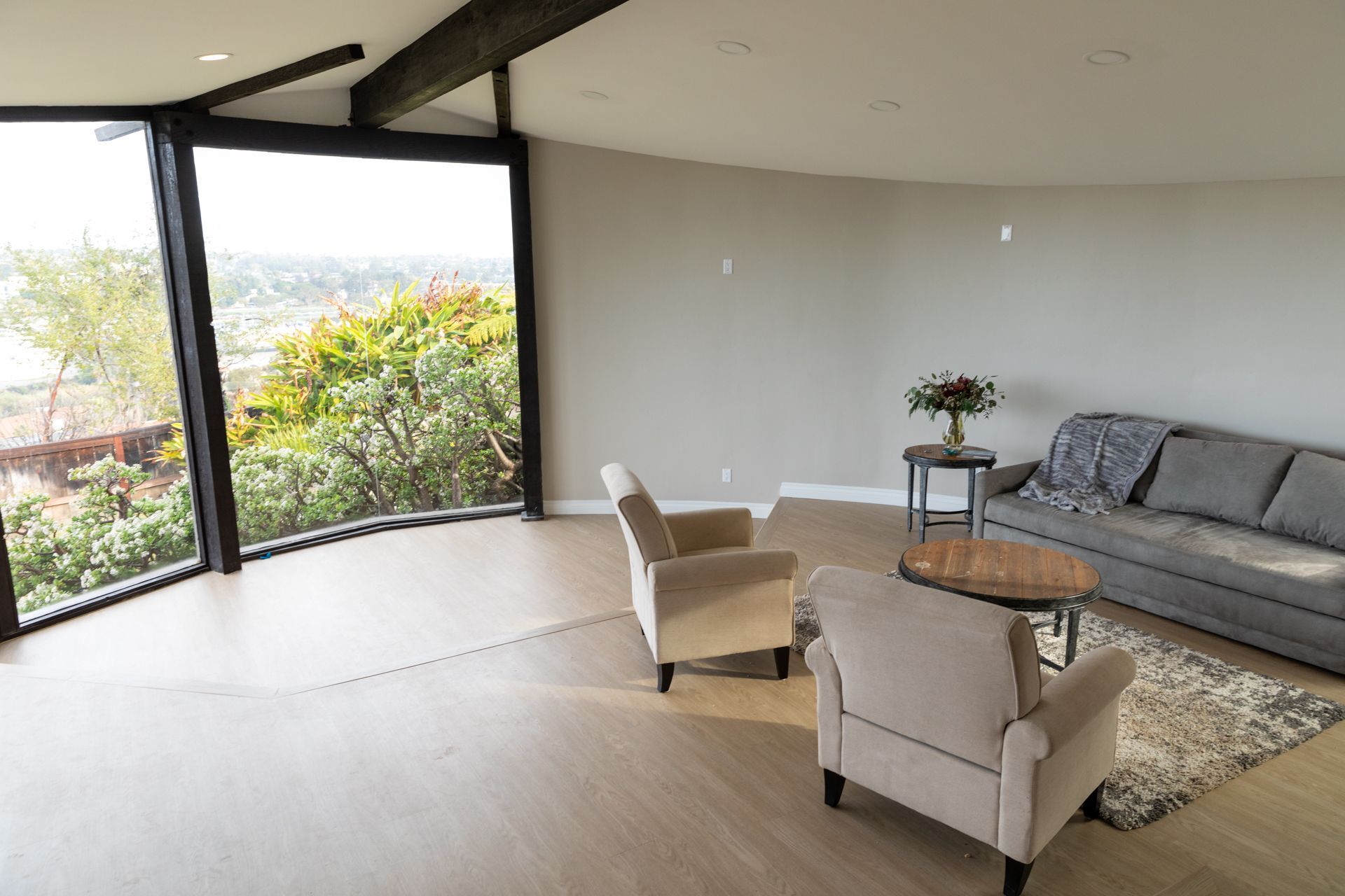 A living room with a couch , chairs , and a table.