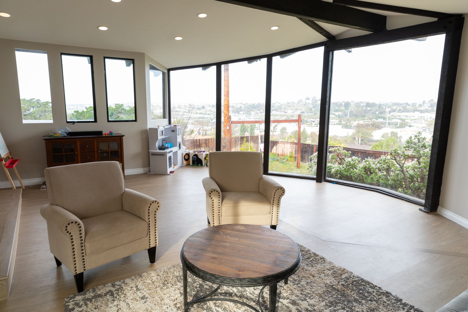 A living room with a lot of windows and chairs