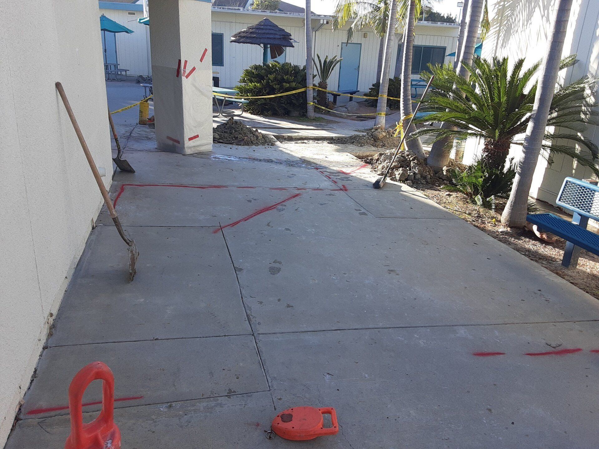 A concrete patio with a broom and a bucket on it