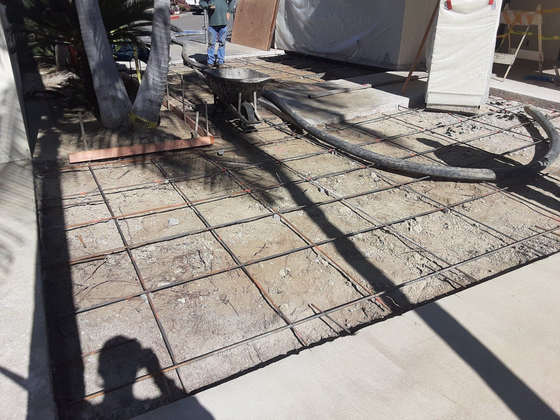 A person is standing on a concrete floor with a hose attached to it.