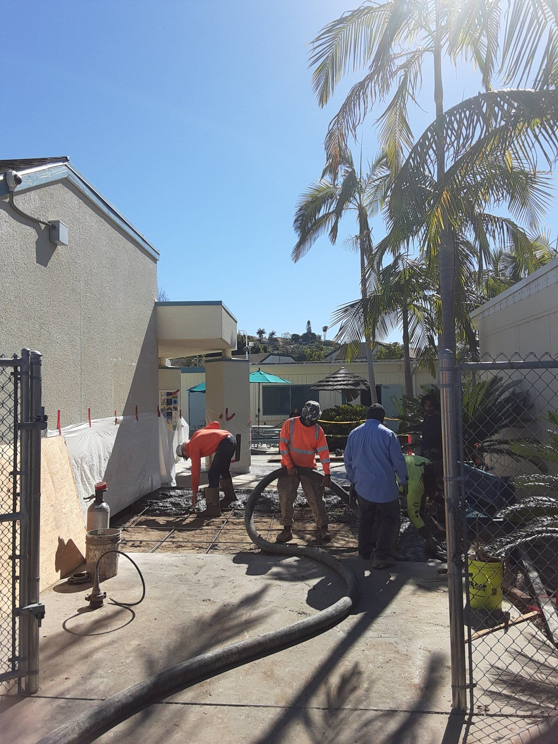 A group of construction workers are working in a backyard