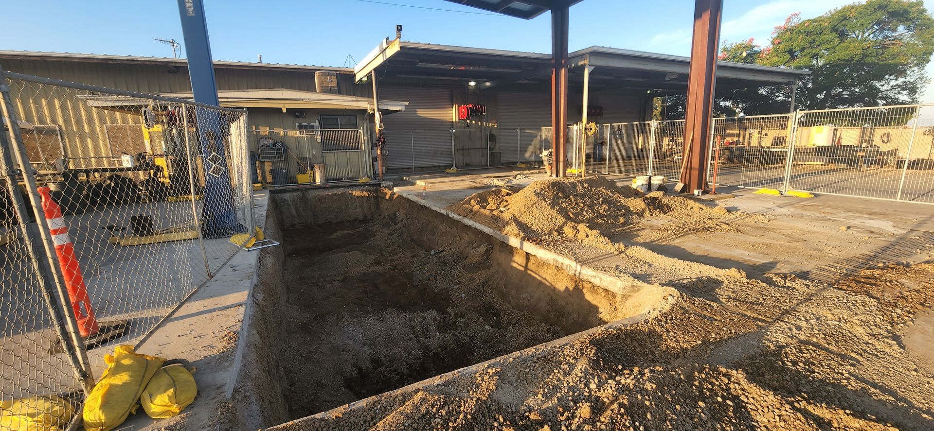 A large pile of dirt is sitting in front of a building under construction.