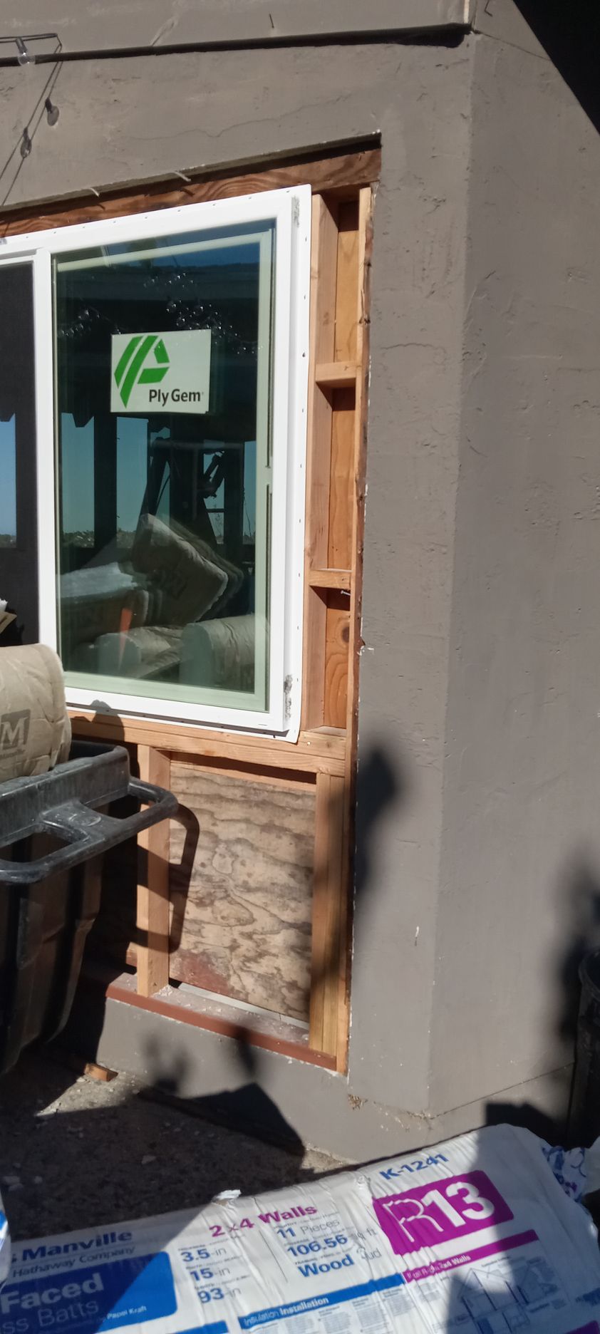 A window is being installed on the side of a house.