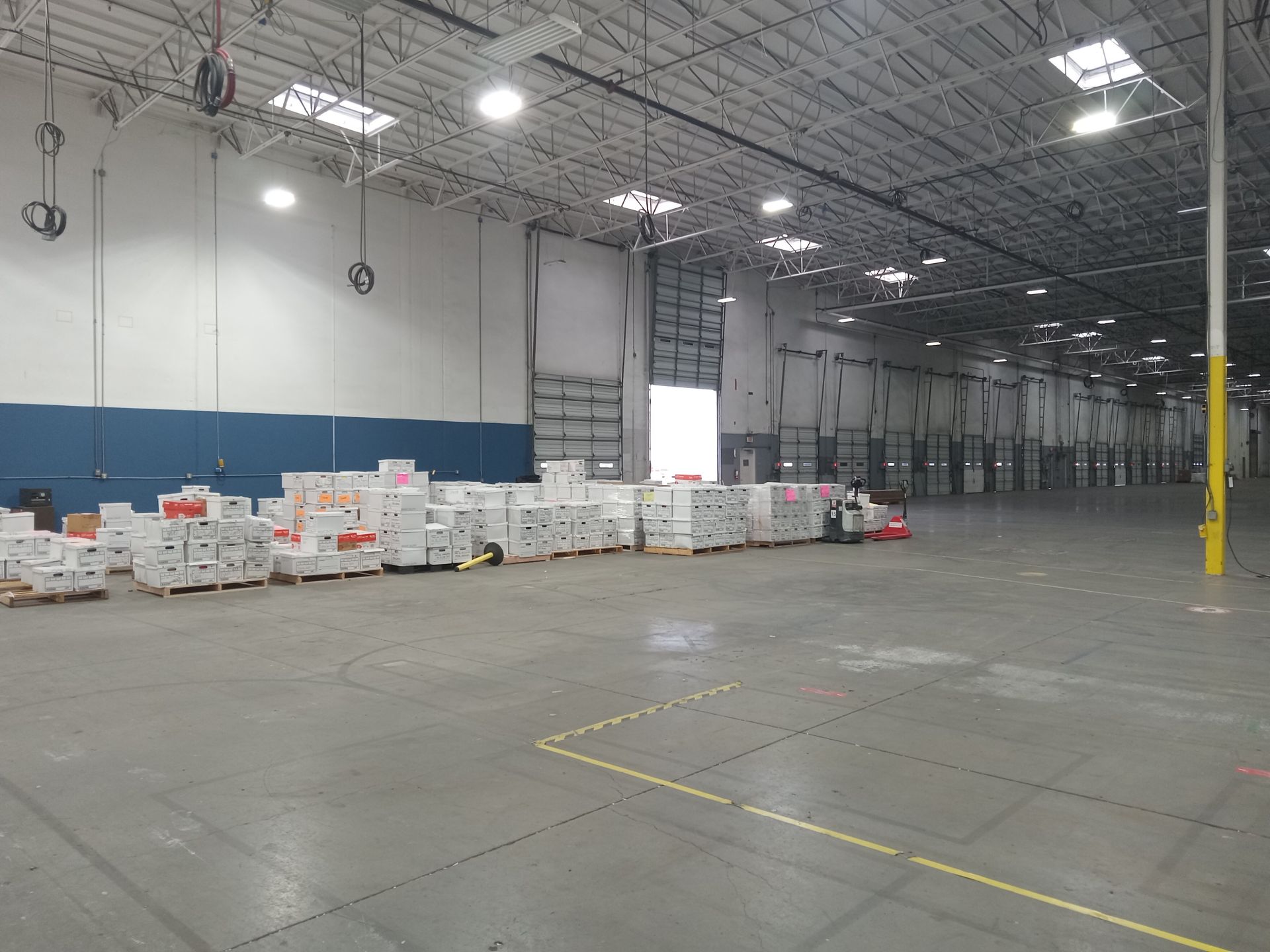 A large warehouse filled with lots of boxes and pallets.