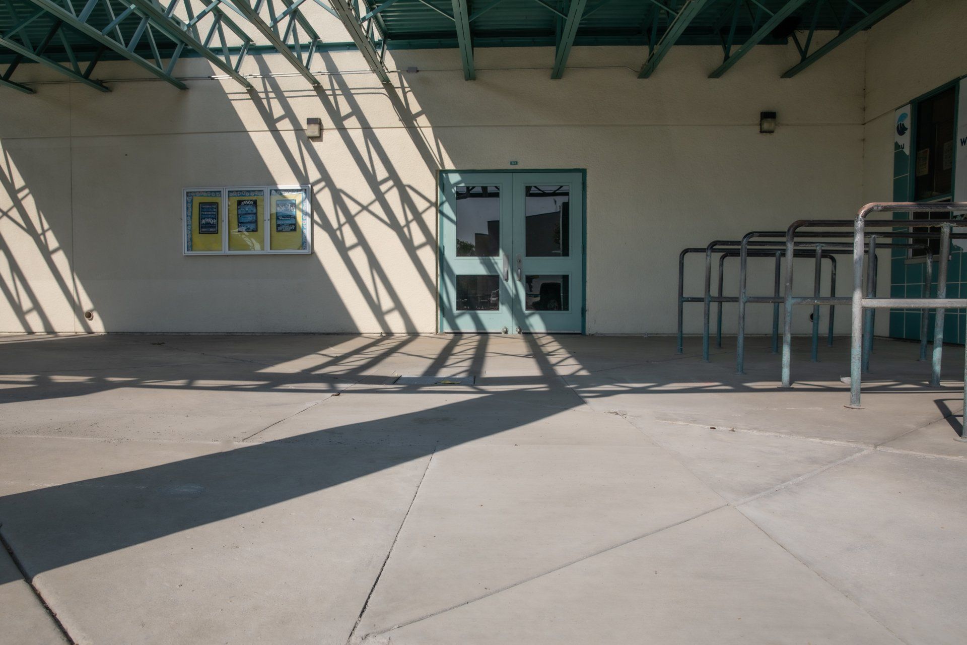 A shadow of a building is cast on a concrete floor