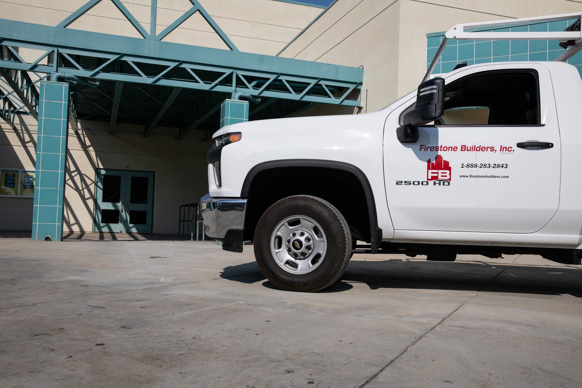A white truck is parked in front of a building.