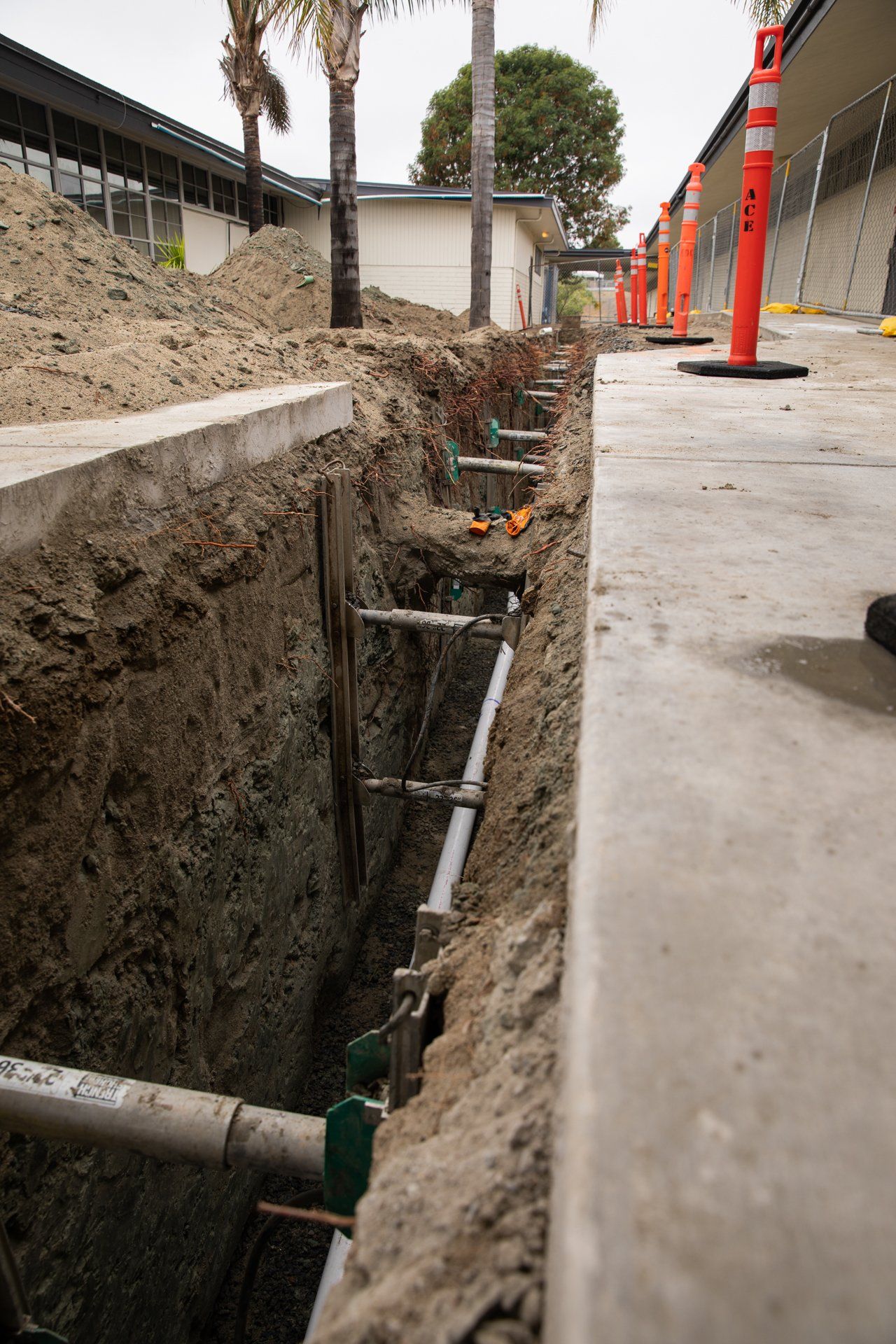 A construction site with a lot of pipes in the dirt