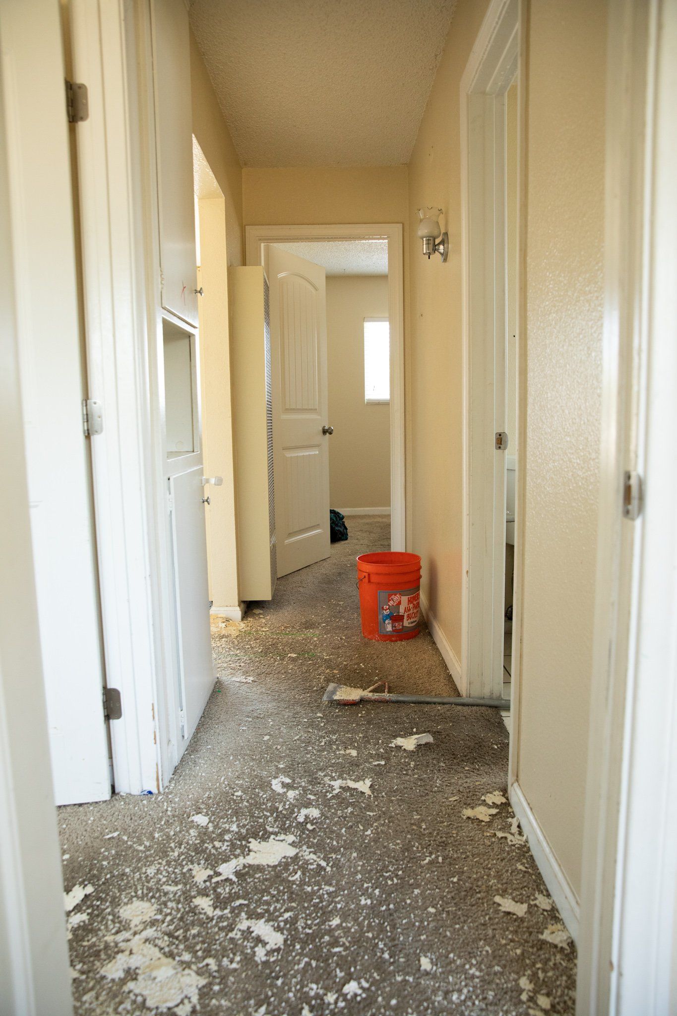 A hallway with a red bucket on the floor