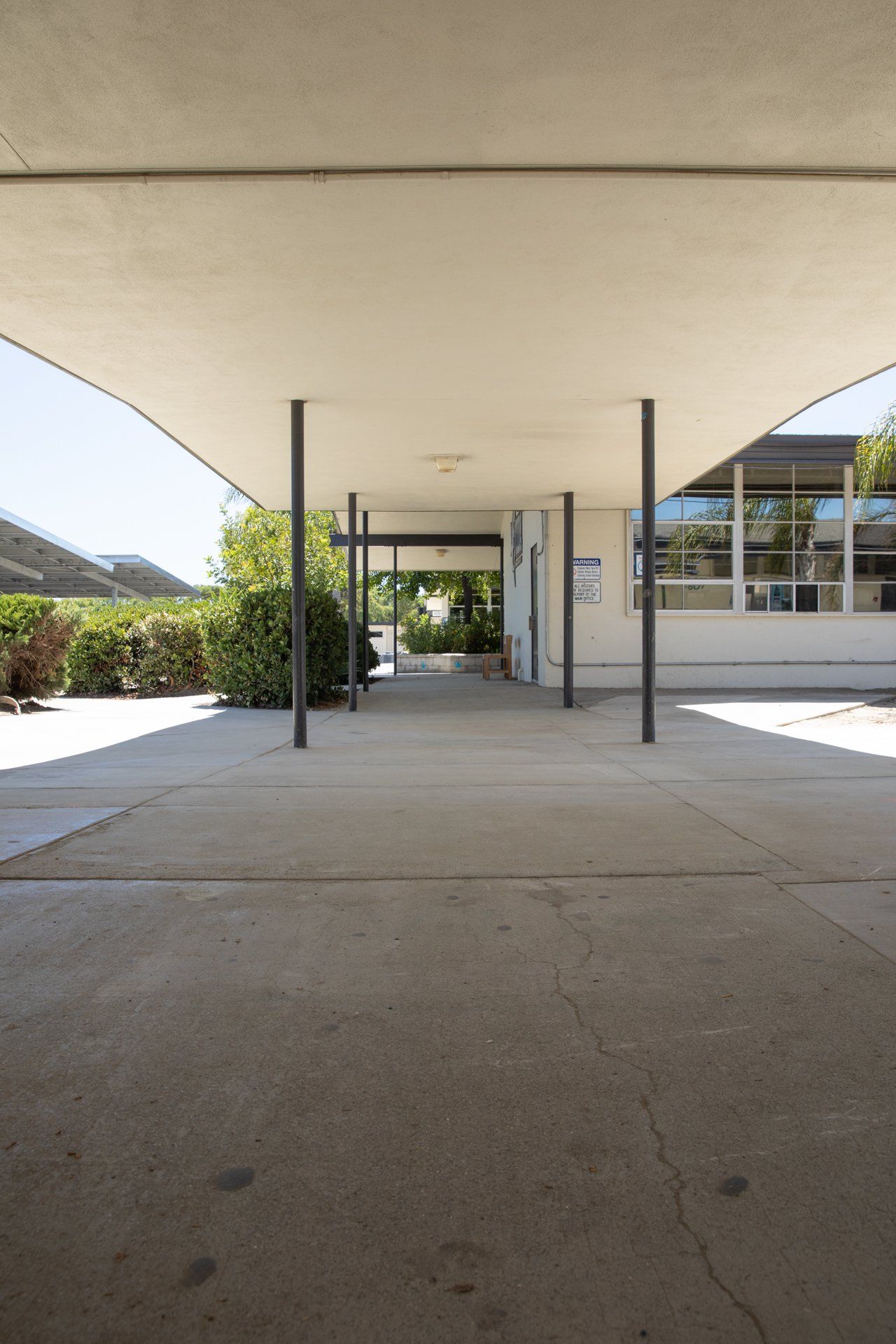 A covered walkway leading to a building with a sign that says ' a ' on it