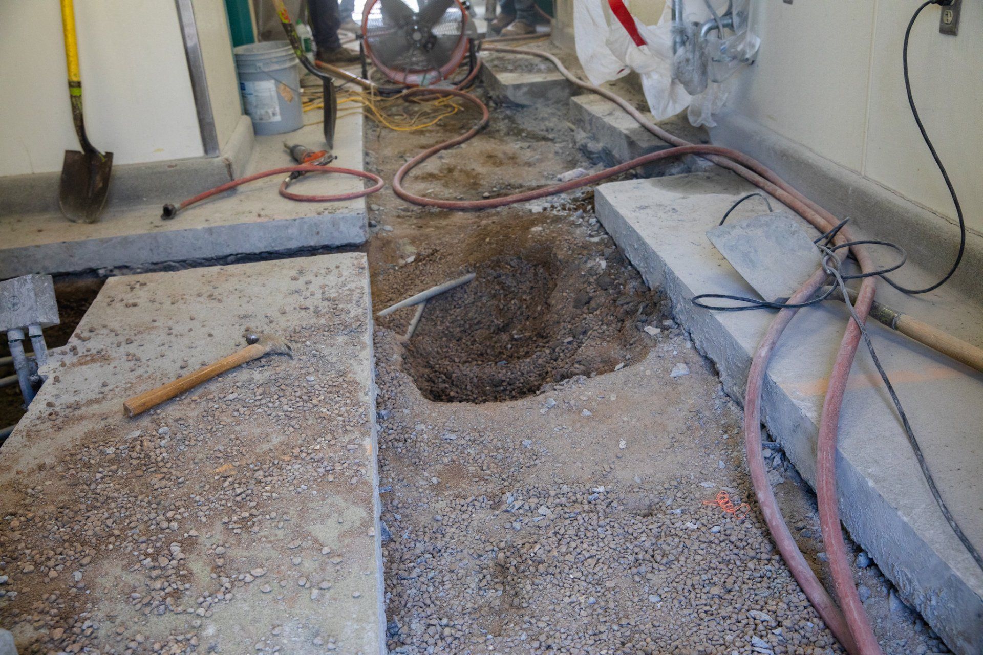 A hole in the ground is being filled with dirt and concrete.