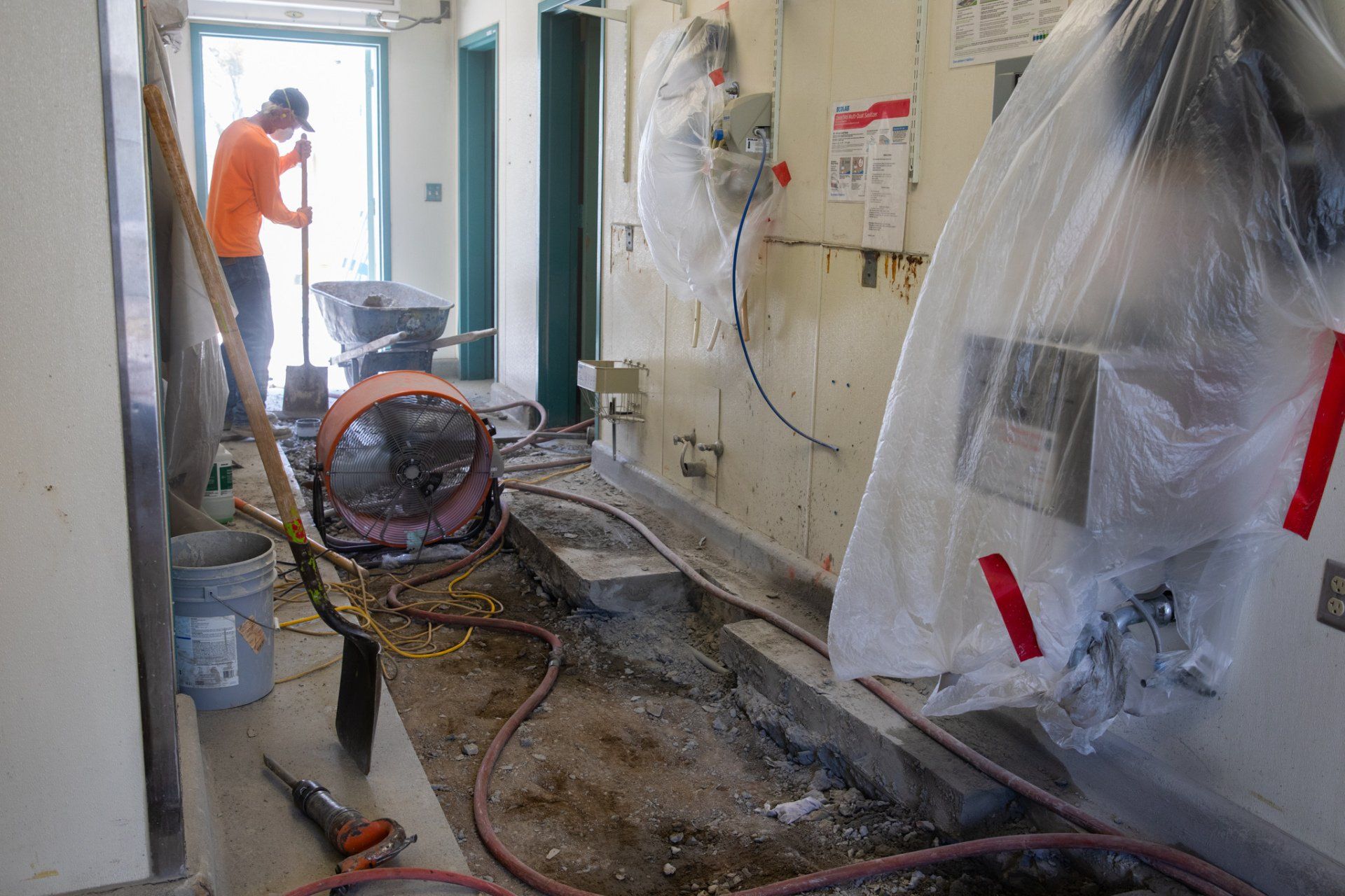 A man is working in a room covered in plastic.